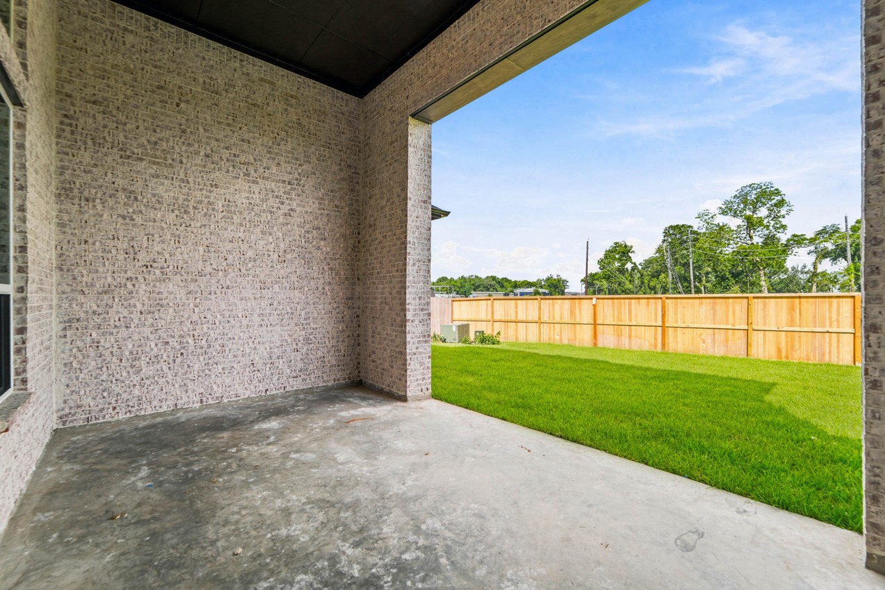 Spacious covered patio overlooking the backyard, perfect for outdoor dining and year-round entertaining.