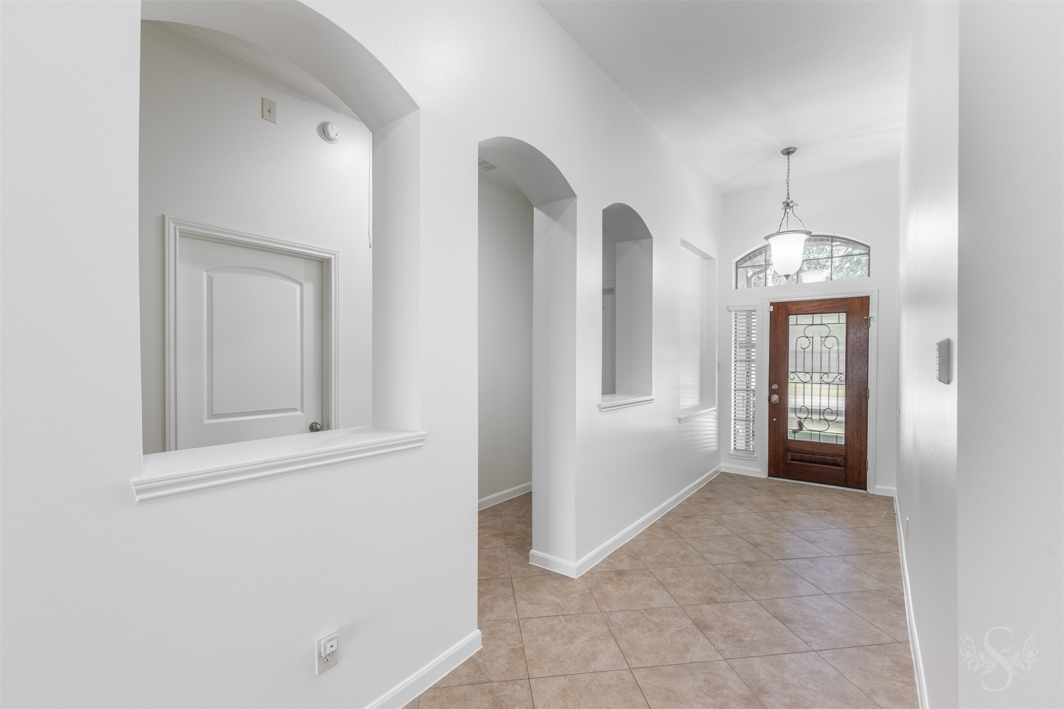 A welcoming gallery-style entry with tray ceiling and graceful archways creates an impressive first impression from the moment you step inside. Beautiful arched openings add architectural character to the hallway leading to the three secondary bedrooms. A welcoming gallery-style entry with tray ceiling and graceful archways creates an impressive first impression from the moment you step inside. Beautiful arched openings add architectural character to the hallway leading to the three secondary bedrooms.