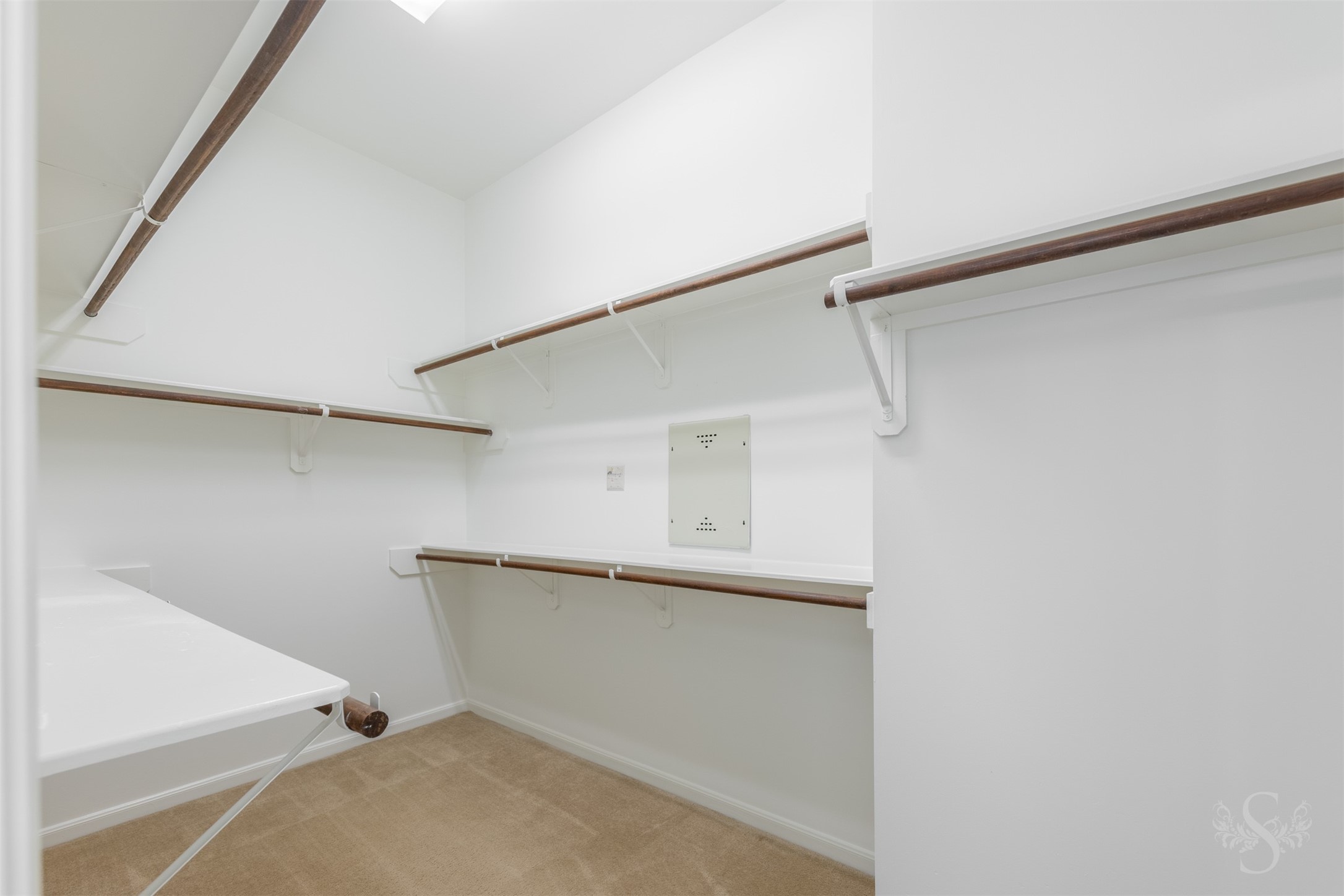 The spacious closet offers abundant shelving and multiple hanging rods to keep clothing, shoes and accessories neatly organized.