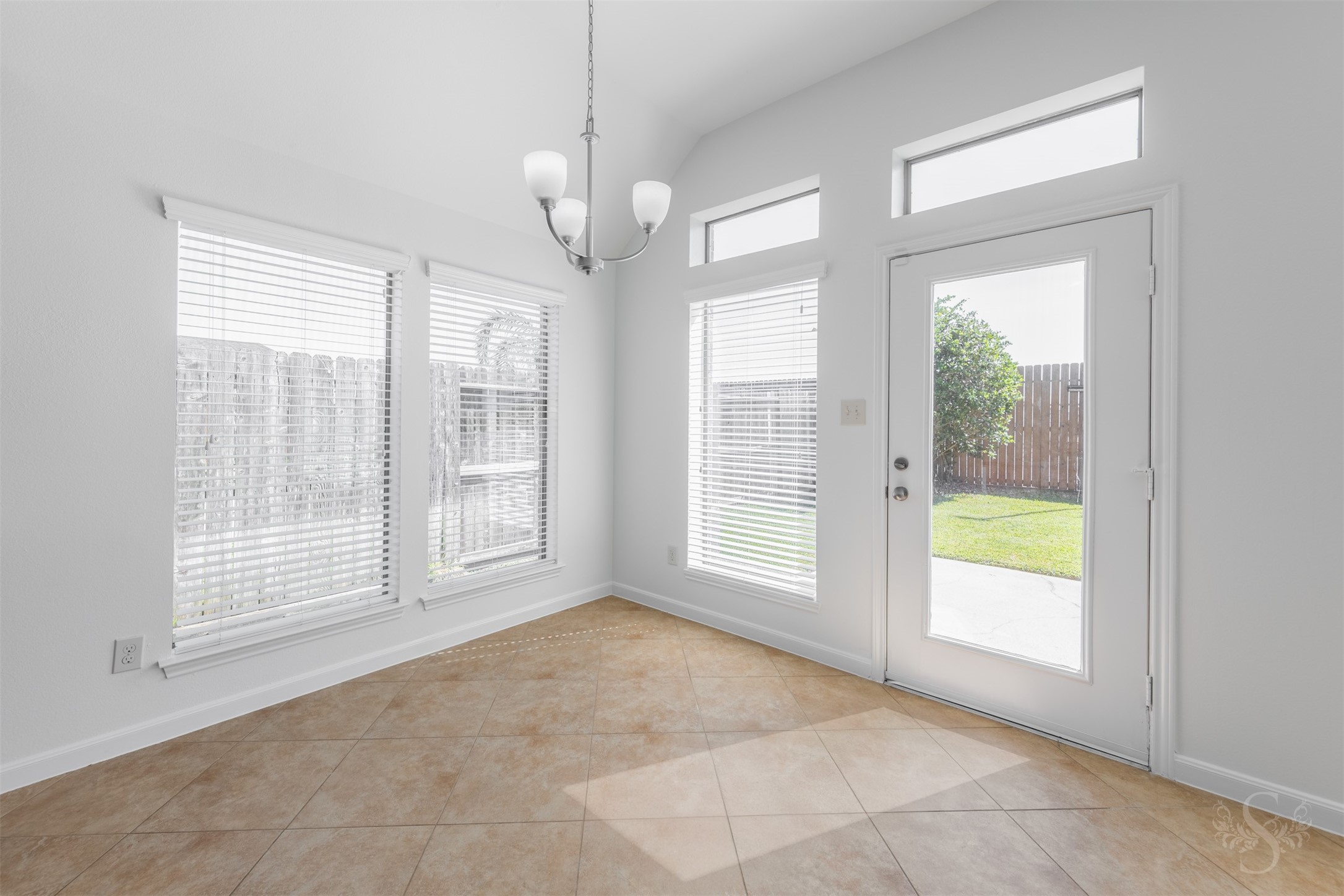 Surrounded by windows and filled with natural light, the breakfast area offers a cheerful space for casual dining and morning coffee. Elevated ceilings and backyard views enhance the bright, open atmosphere.