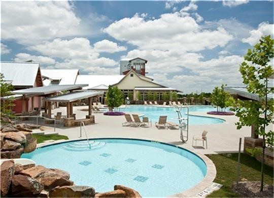 Dive into resort-style living at Cross Creek Ranch! This is just one of three sparkling pools residents enjoy, complete with a splash pad and scenic lake views. Whether youre cheering on the neighborhood swim team or relaxing poolside under the Texas sun, every day feels like a getaway. Dont miss the iconic Lookout Tower in the distanceanother hallmark of this vibrant community.