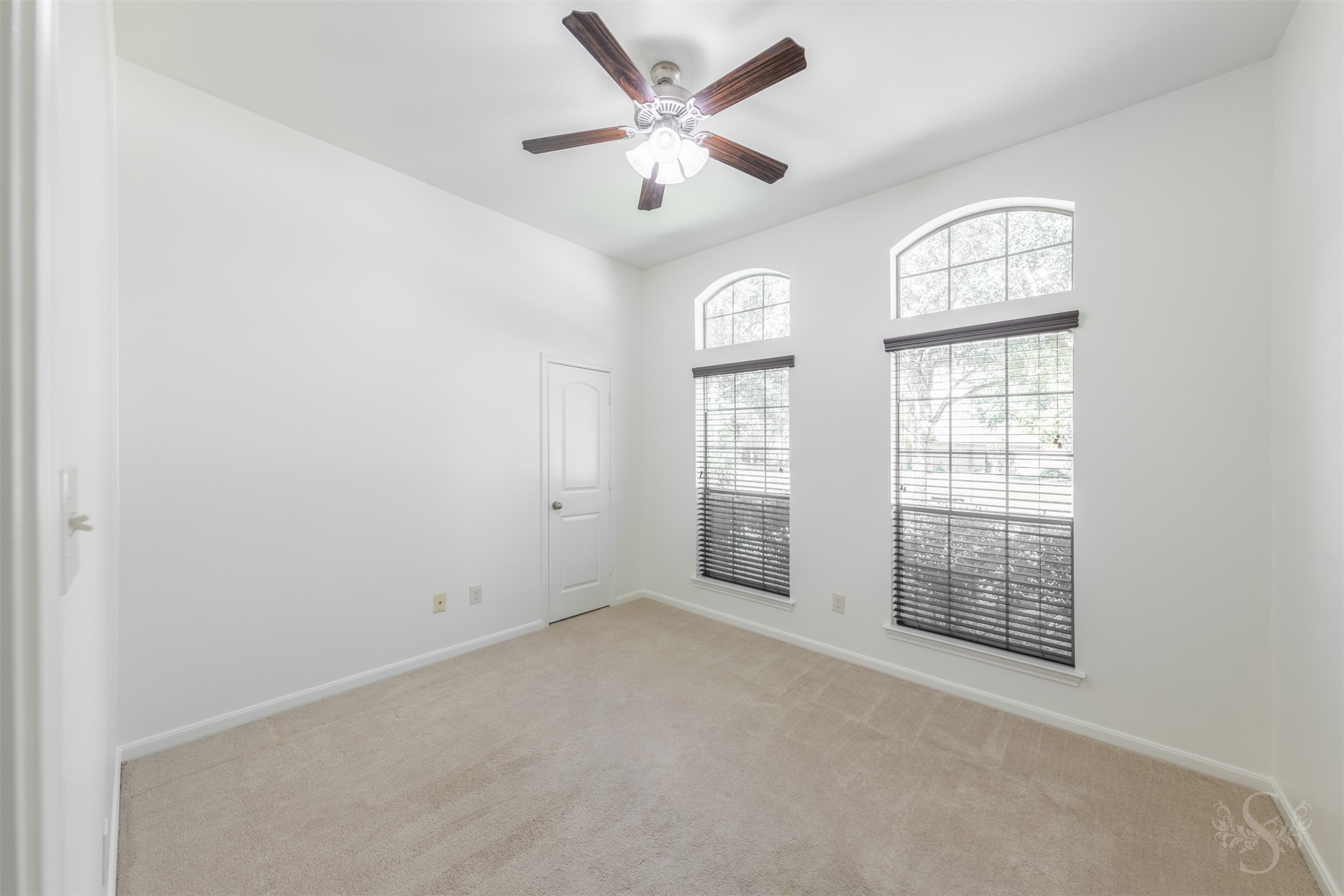 This secondary bedroom features elevated ceilings, plush carpeting and large windows that bring in soft natural light. Generous space and a comfortable layout make it ideal for family or guests.