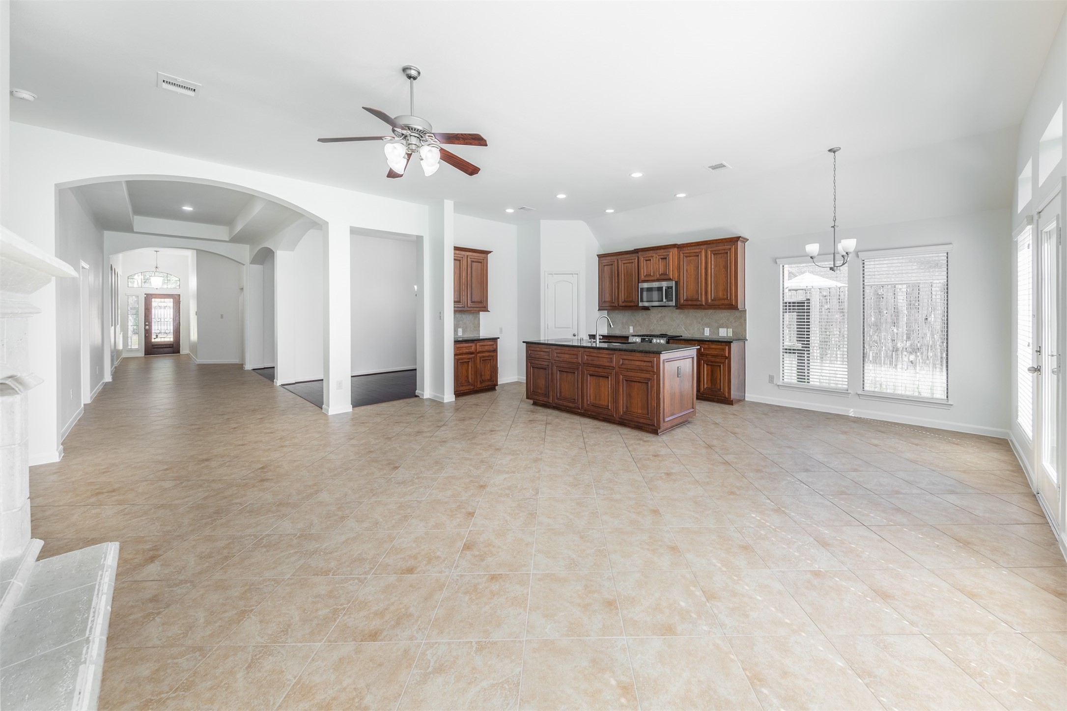 The spacious family room offers an inviting setting for relaxing or gathering, with open sightlines, recessed lighting and graceful archways enhance the homes airy, connected design.