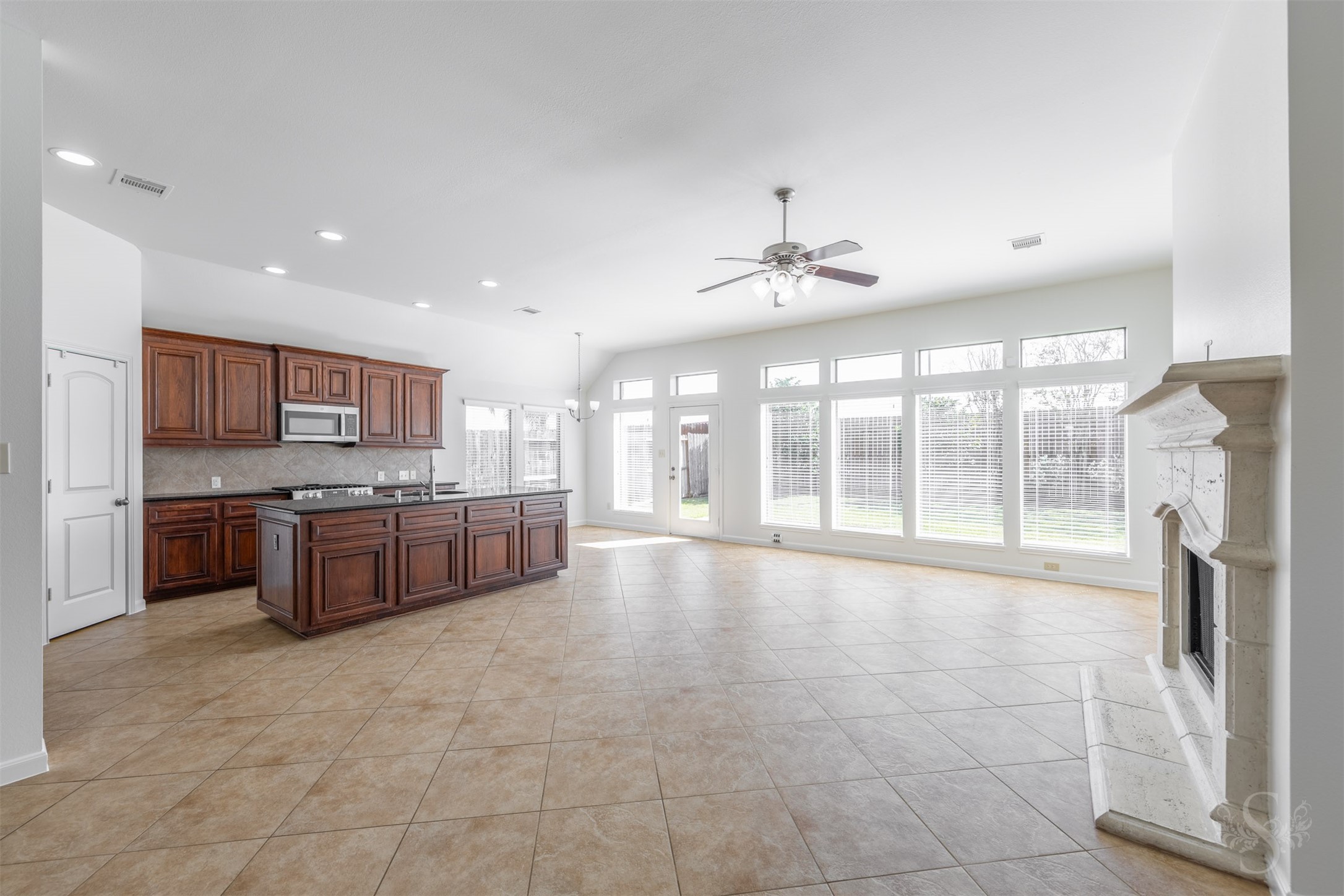 The spacious open-concept family room is filled with natural light from a wall of windows and features a beautiful fireplace that creates a warm, inviting focal point. Neutral finishes, soaring ceilings and seamless flow into the kitchen and breakfast areas make this space ideal for both relaxing and entertaining. The spacious open-concept family room is filled with natural light from a wall of windows and features a beautiful fireplace that creates a warm, inviting focal point. Neutral finishes, soaring ceilings and seamless flow into the kitchen and breakfast areas make this space ideal for both relaxing and entertaining.