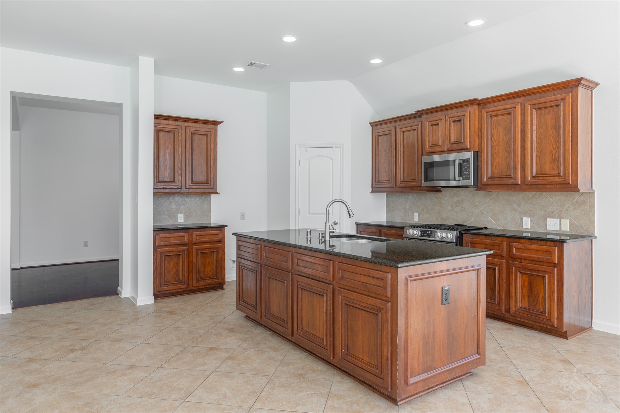 Chefs kitchen showcases gorgeous granite counters and island, stainless steel appliances and an abundance of cabinets for your storage needs.