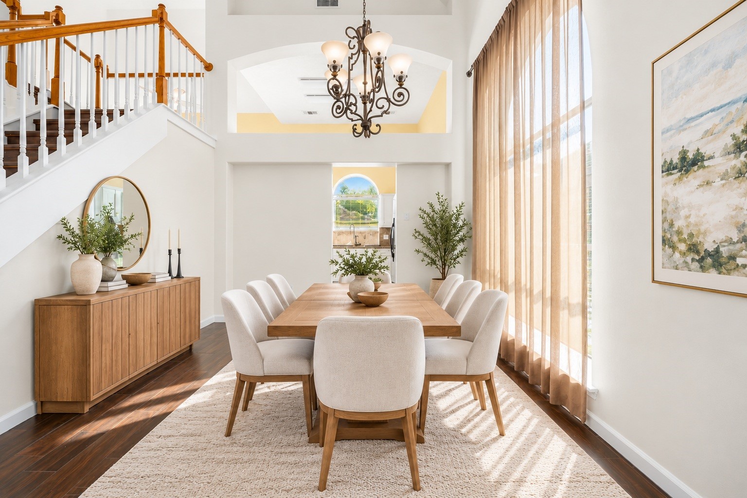 The formal dining area is framed by an elegant chandelier and tall windows, offering a sophisticated space for gatherings. Virtually staged.