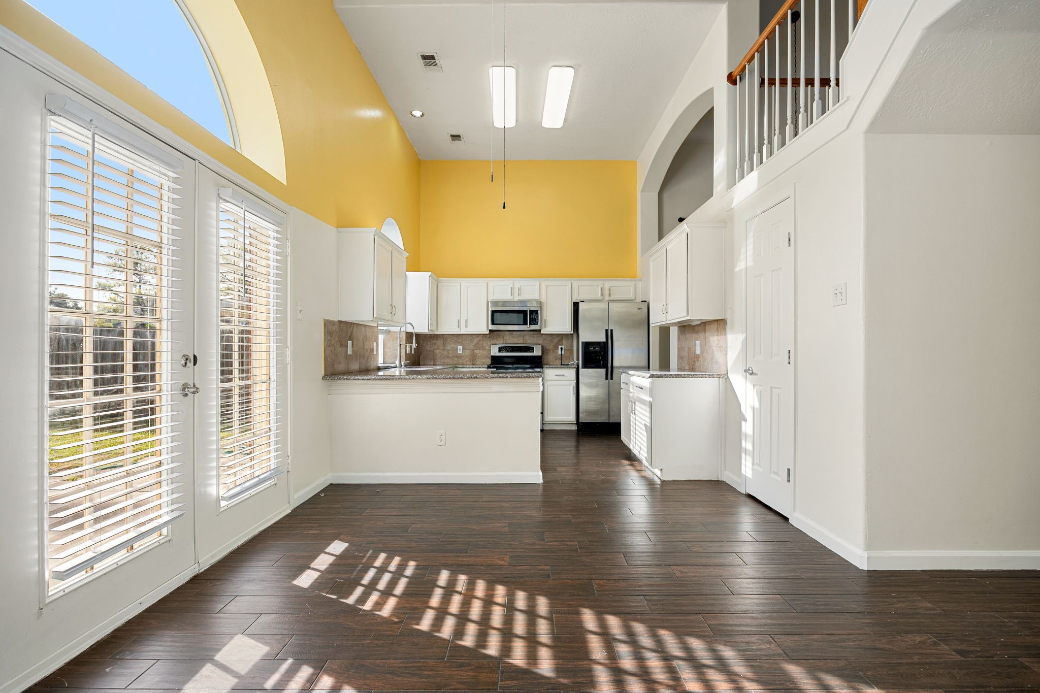 The sunny breakfast area offers direct access to the backyard through French doors, ideal for casual meals or morning coffee.