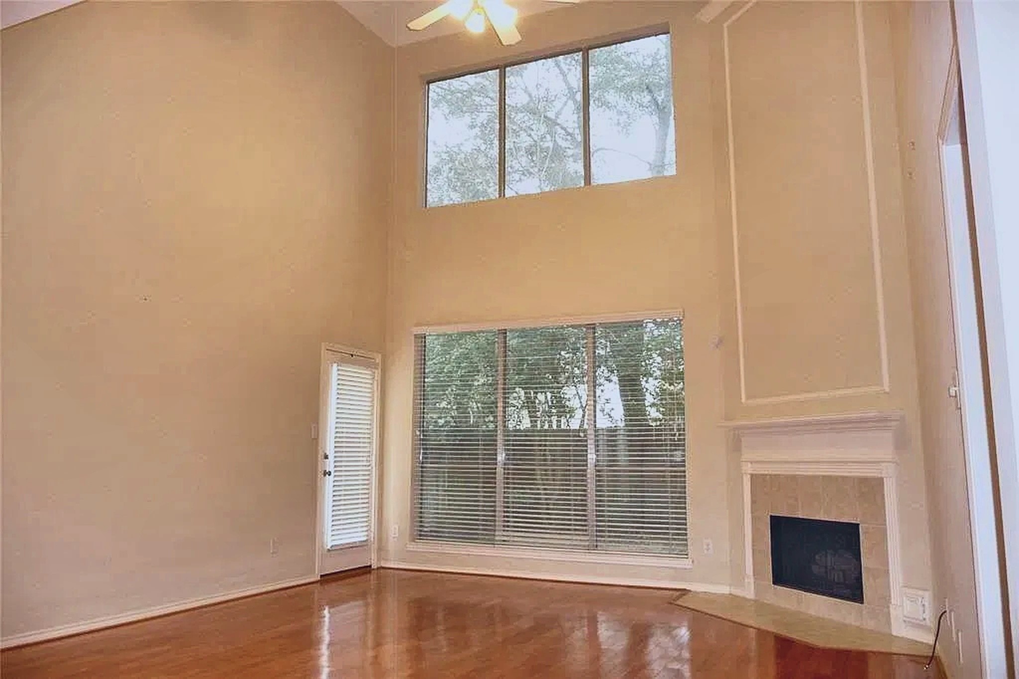 Soaring two-story living room with gas-log fireplace and gleaming hardwood floors. Soaring two-story living room with gas-log fireplace and gleaming hardwood floors.