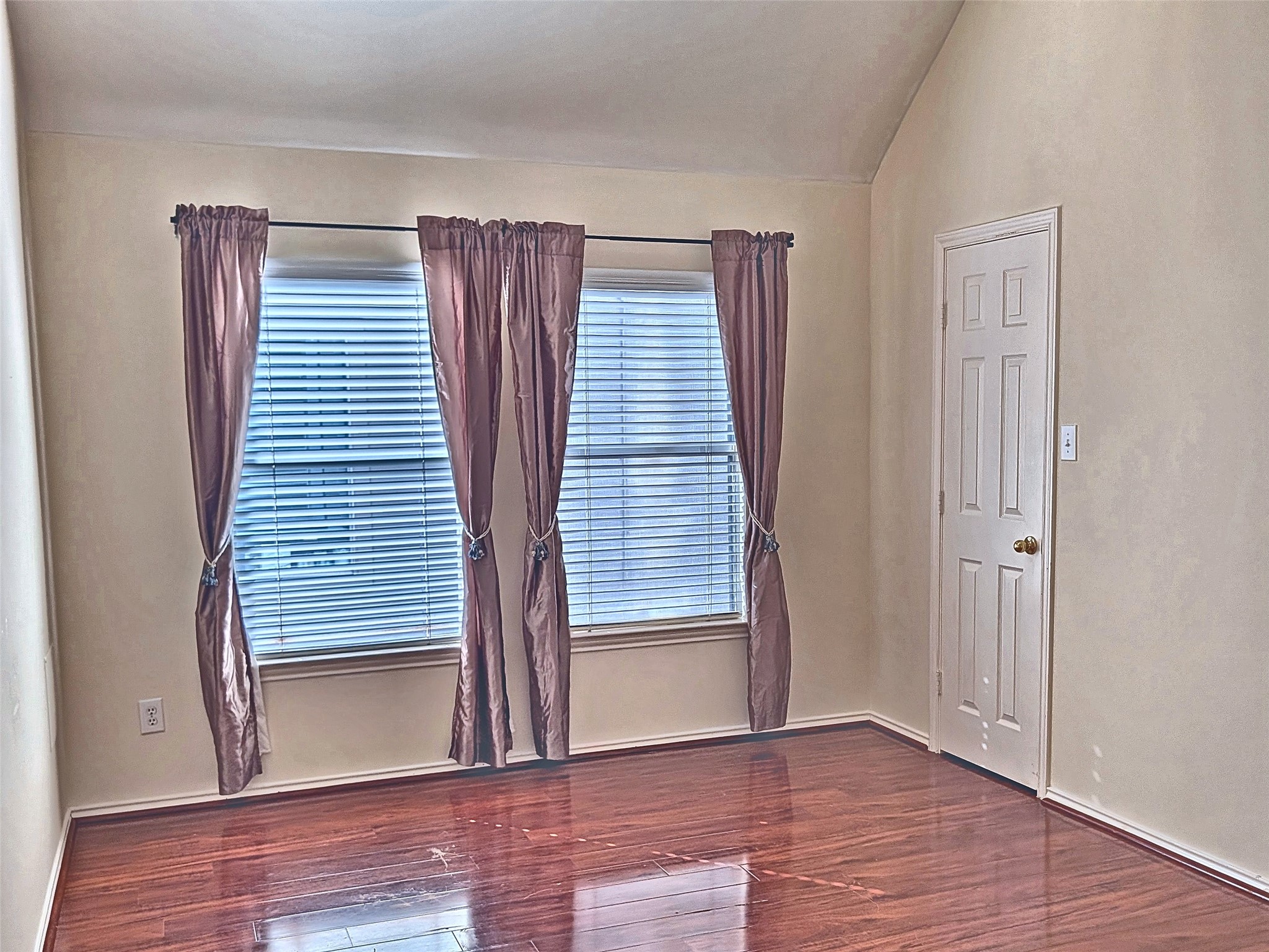 Spacious secondary bedroom with tray ceiling and cooling ceiling fan.