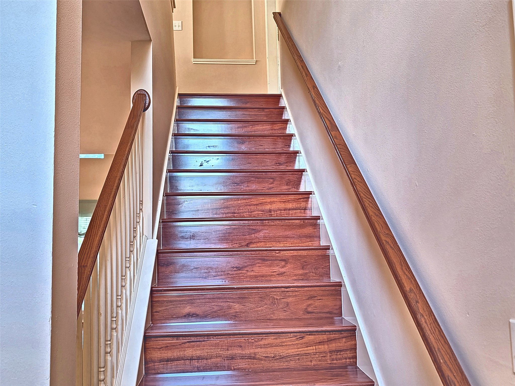 Hardwood staircase with classic white spindles leading to upper level.