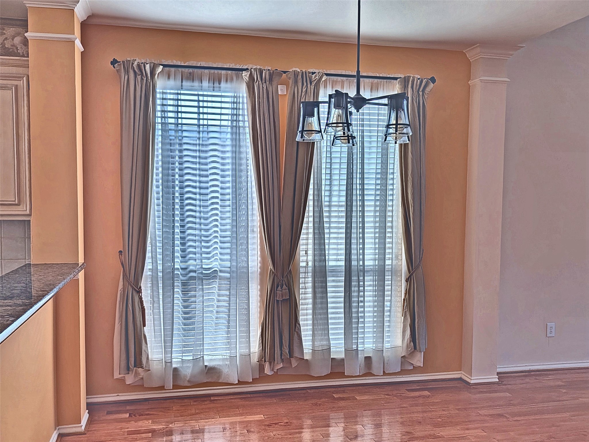 Elegant formal dining area with double windows and rich wood flooring. Elegant formal dining area with double windows and rich wood flooring.
