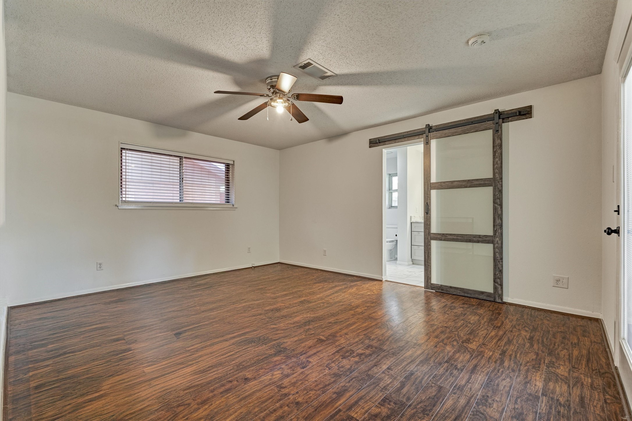 Spacious primary featuring an updated ensuite bathroom and private exterior access to the backyard.