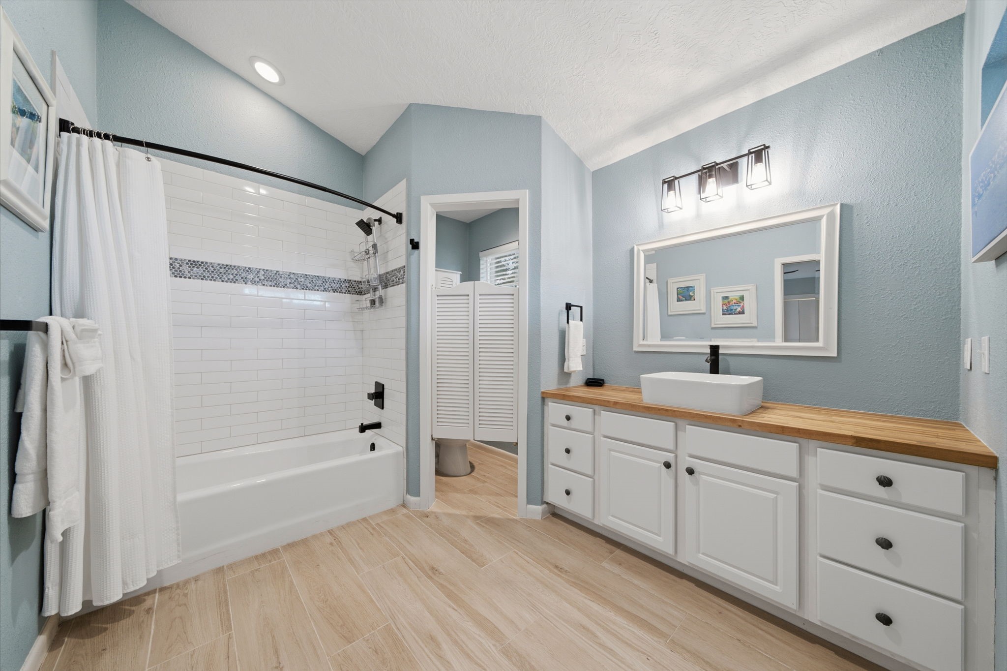 Second of THREE gorgeous remodeled bathrooms with plenty of room; access to the shared deck.