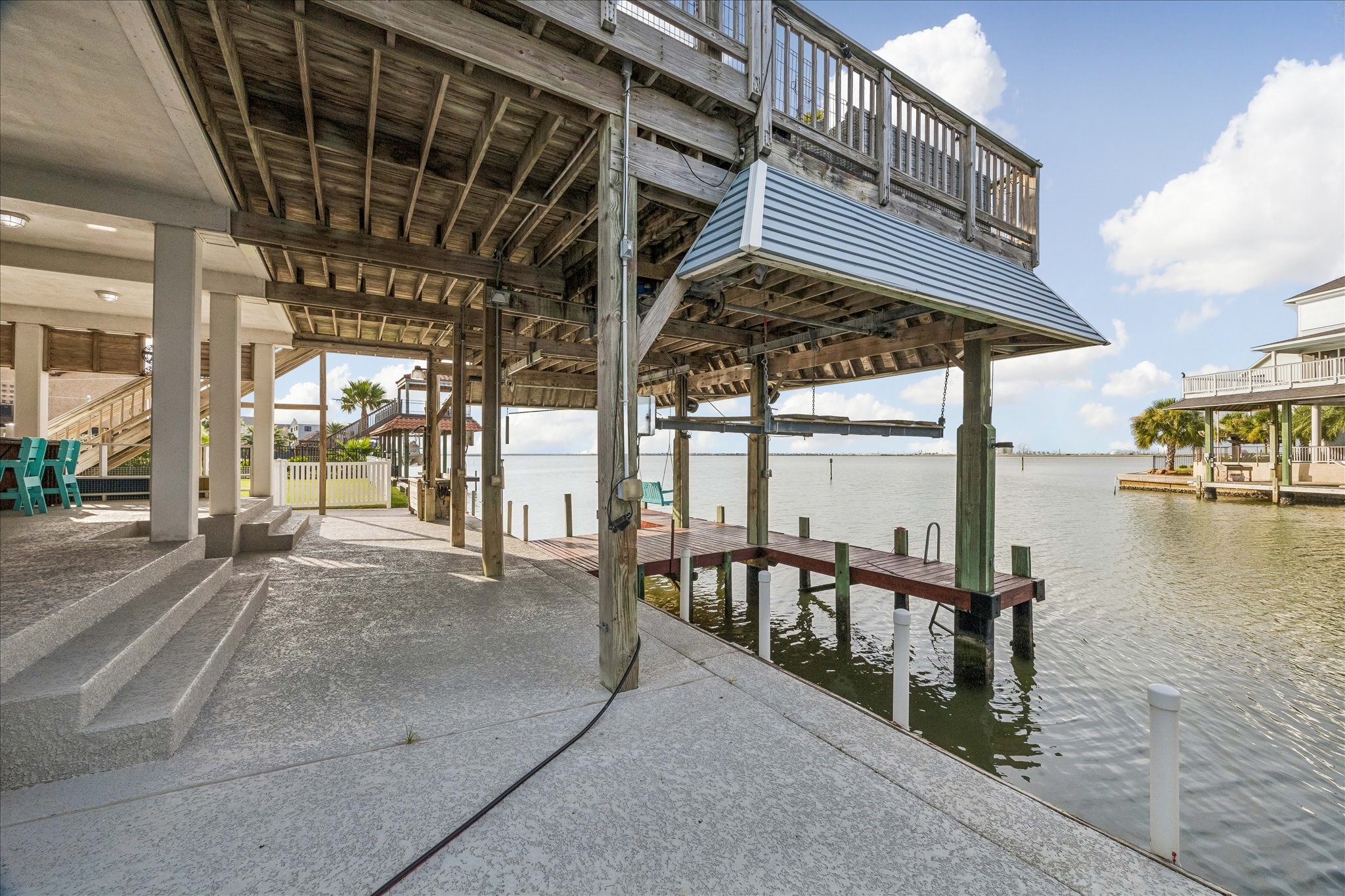 Cool Deck has recently been added to all flooring underneath the home & in the garage area. Large dockside living area with a concrete bulkhead, offering a versatile waterfront space.