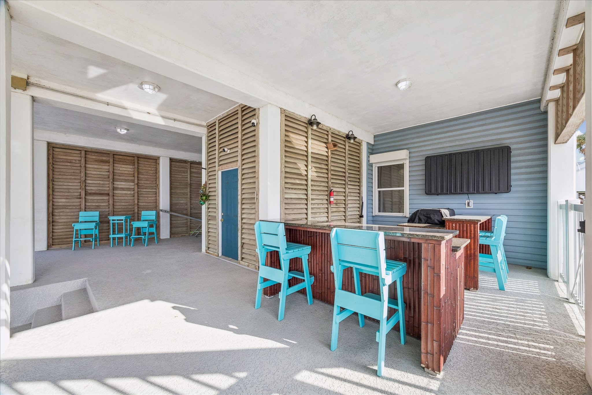 Outdoor bar and grill area with granite countertops and an outdoor flatscreen TV & weatherproof housing recently installed, creating the perfect waterfront gathering space for grilling, entertaining, and relaxing by the pool. Enjoy easy access to the dockside living area and Bay, making outdoor entertaining effortless. The BBQ grill stays with the home.