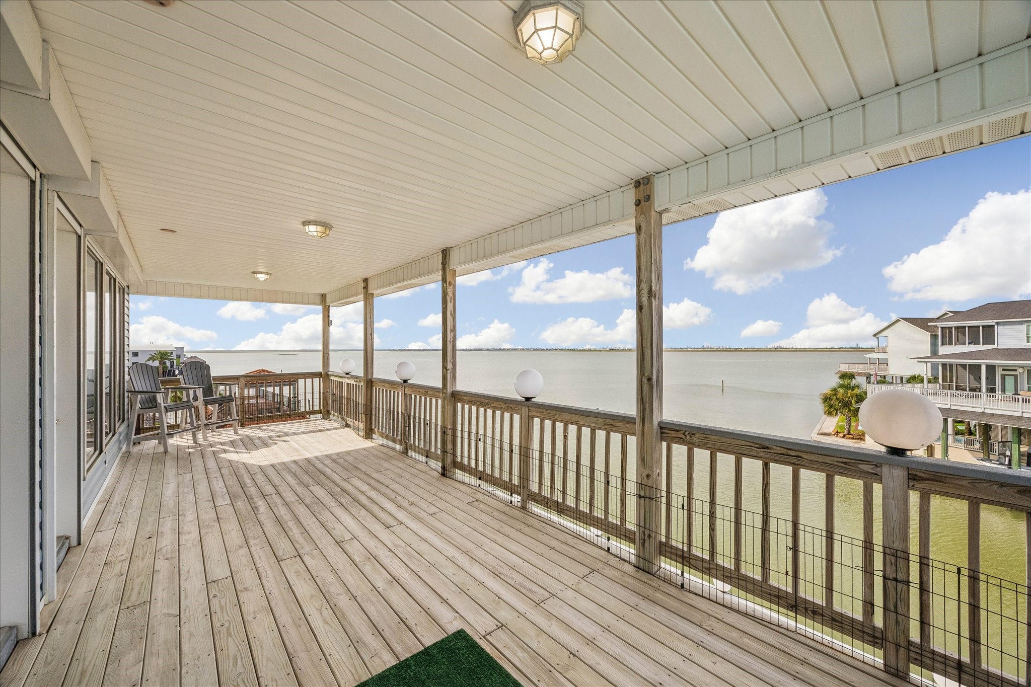 Large third-level balcony overlooking the Bay, offering plenty of room for outdoor furnishings, dining, and entertaining. Both primary suites provide direct access to this impressive waterfront outdoor space.