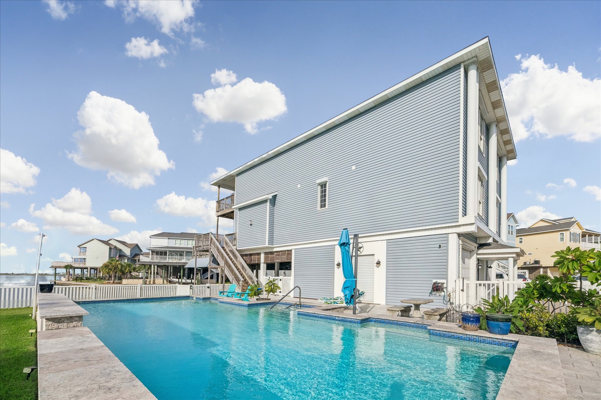 MASSIVE pool includes a beautiful waterfall feature (See video link) creating a relaxing backyard retreat perfect for enjoying the coastal setting. 10X10 ft Cantilever Patio umbrella, base & solar lights.