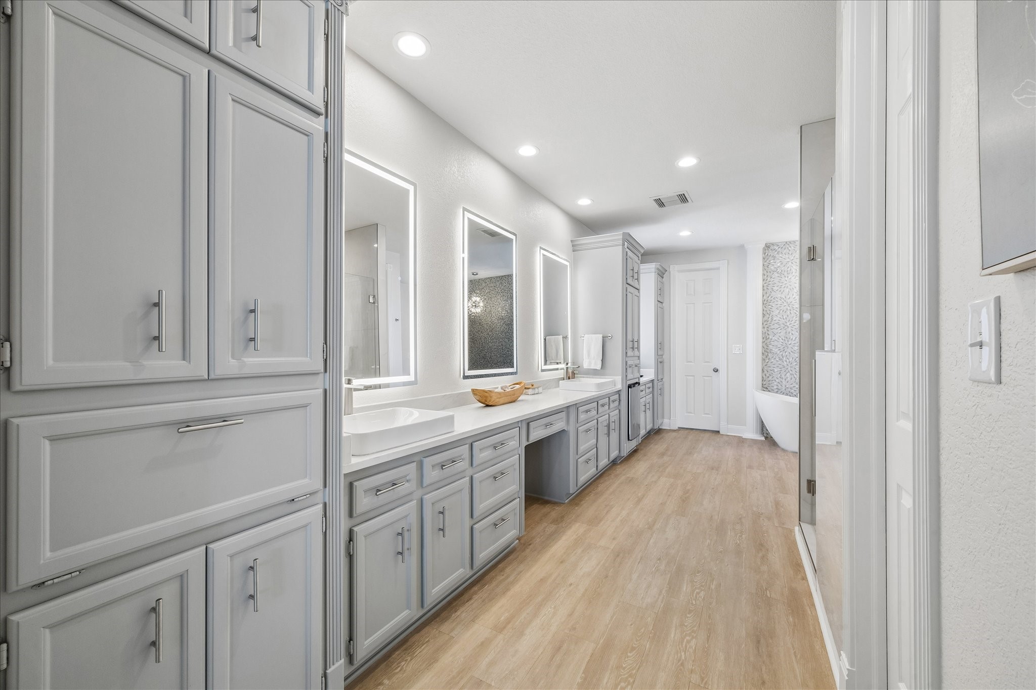 Light and airy primary bathroom with beautifully appointed dual vanities, ample cabinetry, and a clean, fresh design. Thoughtful storage and separate vanity areas provide both style and functionality. Bathroom cabinets have been freshly painted with new hardware installed.