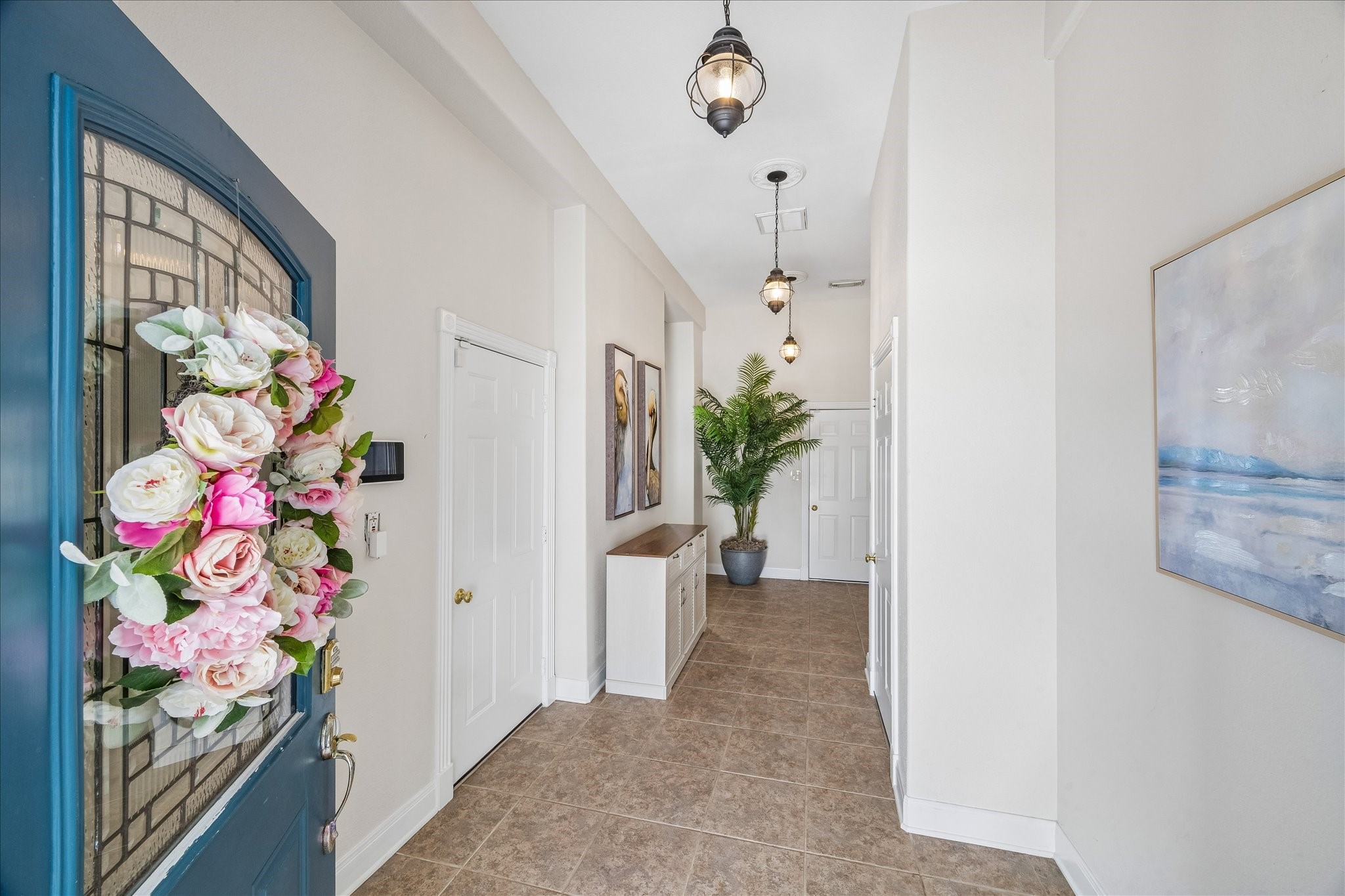 Welcoming leaded-glass framed entry opens to a spacious tiled foyer with convenient access to two single-car garages, a tackle/flex room with refrigerator, and outdoor dockside living. Enjoy easy access to the double boathouse and waterfront, creating an ideal setup for coastal living.