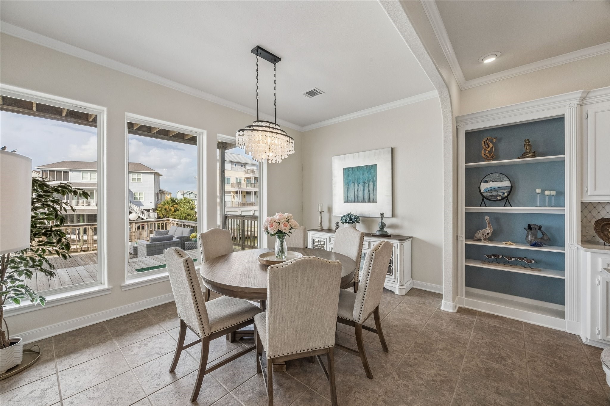 Sizable dining area with tile flooring, a striking new chandelier, bookshelves and a wall of windows overlooking the Bay, creates an inviting setting for meals and entertaining with beautiful waterfront views.