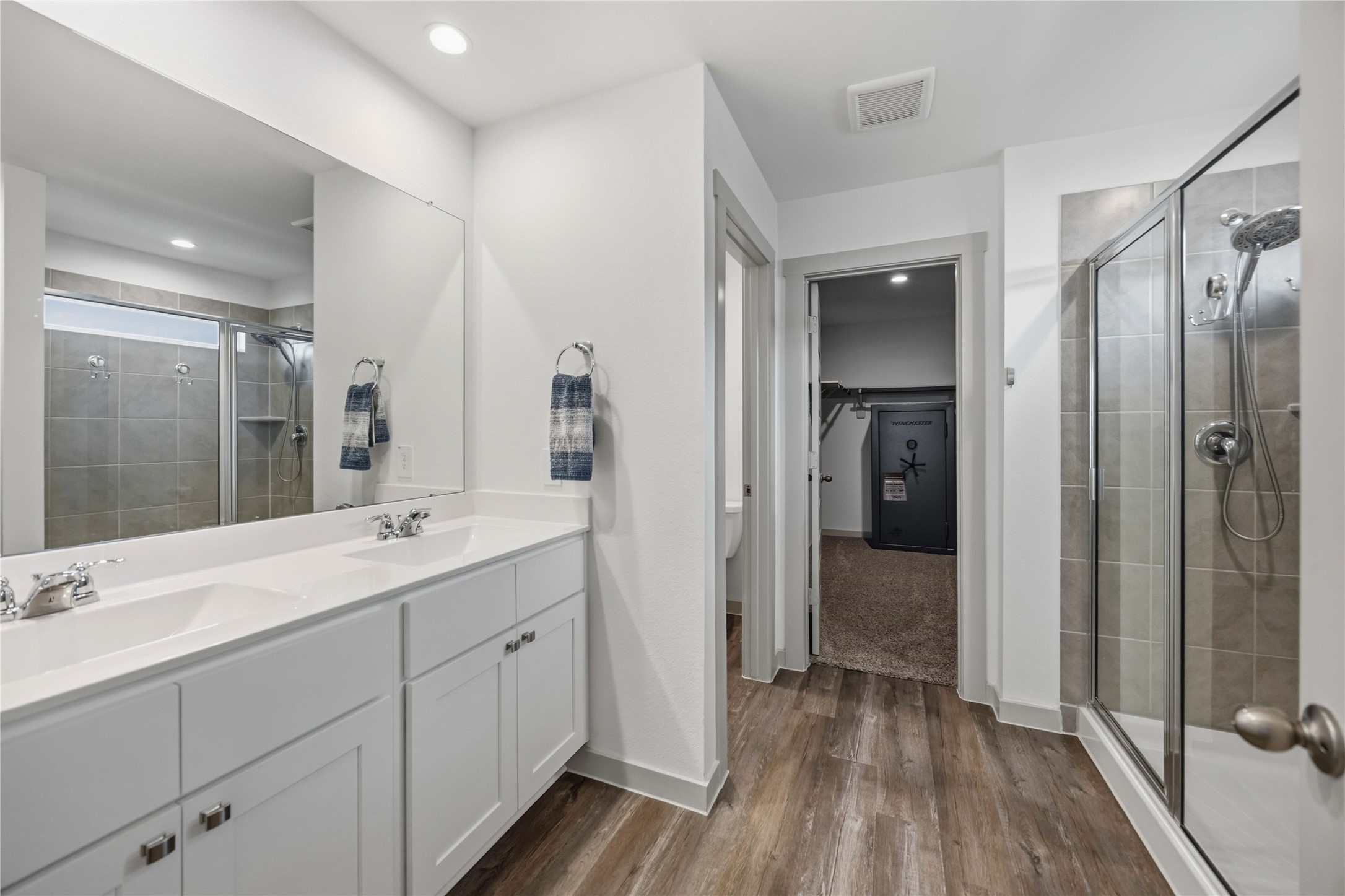 The primary bath features and oversized stand alone shower with tile surround and double sink vanity.