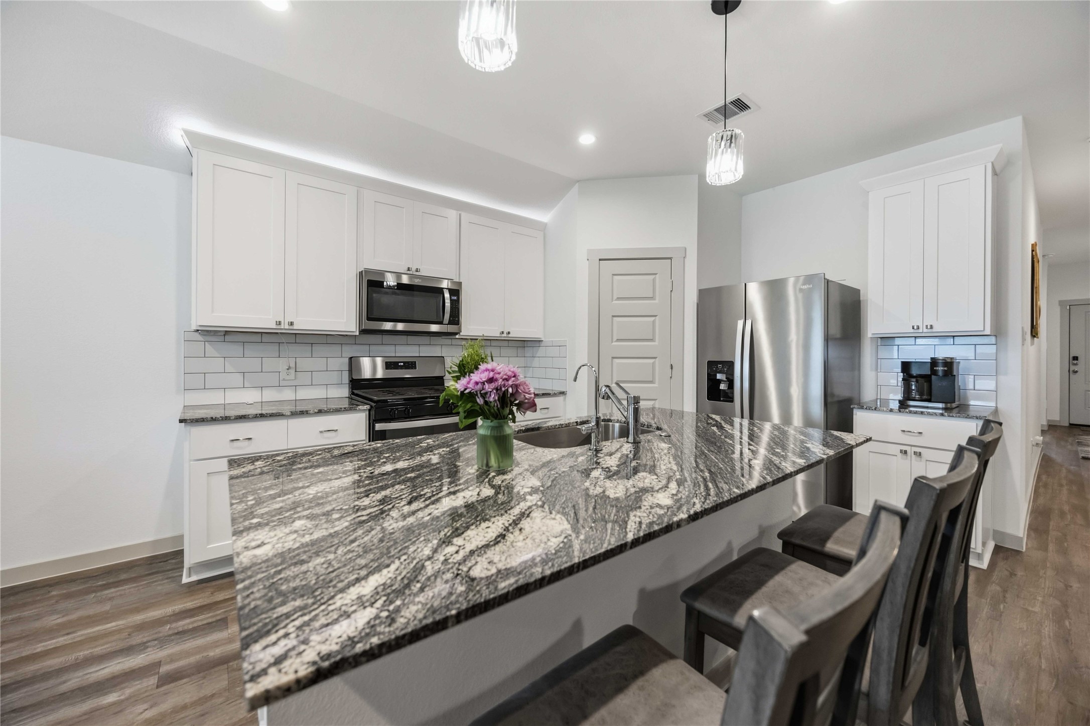 The kitchen offers granite counter tops, coffee bar and custom tile backsplash.