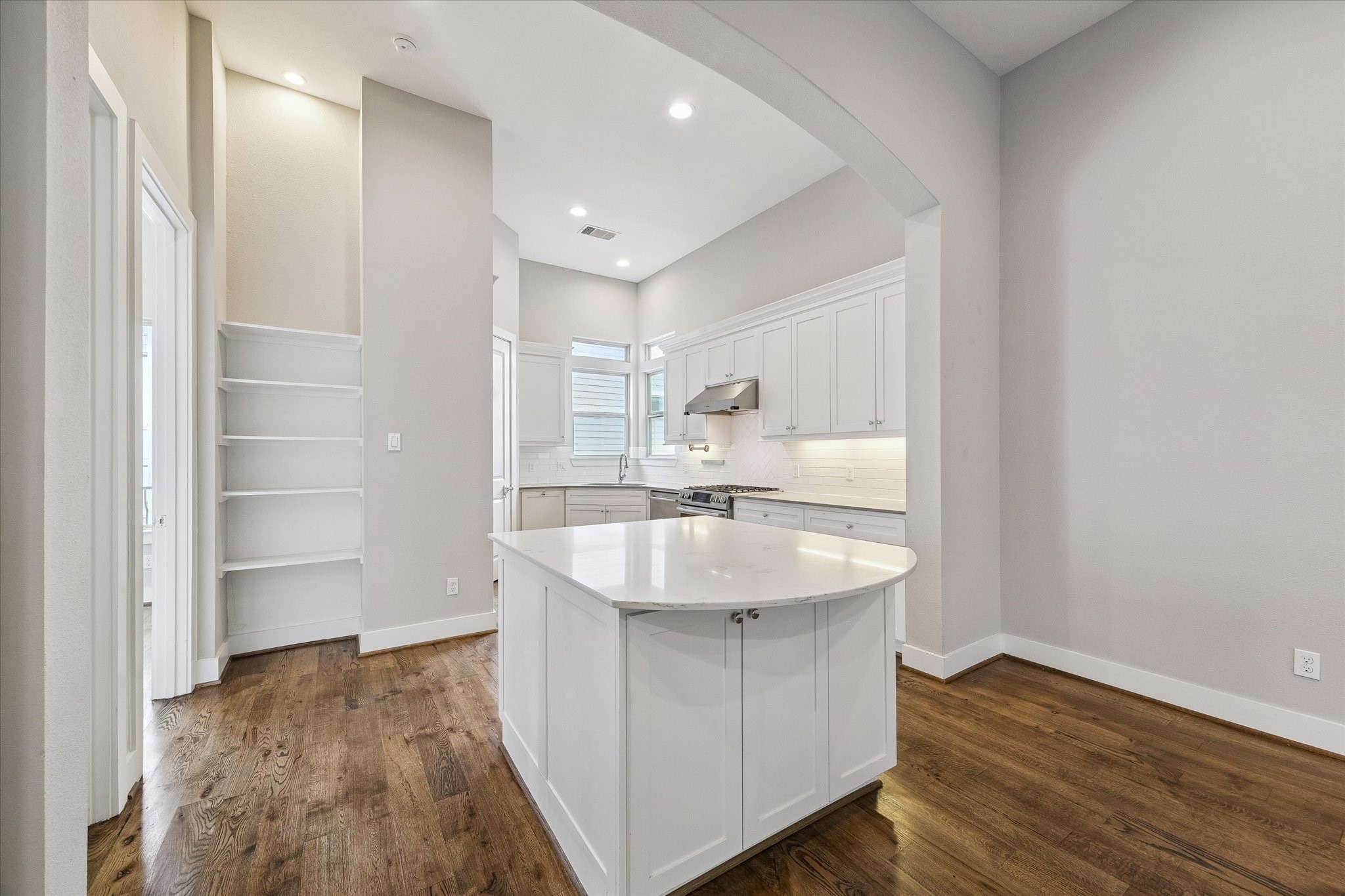 Beautiful kitchen with an island, full pantry, and additional storage shelves.