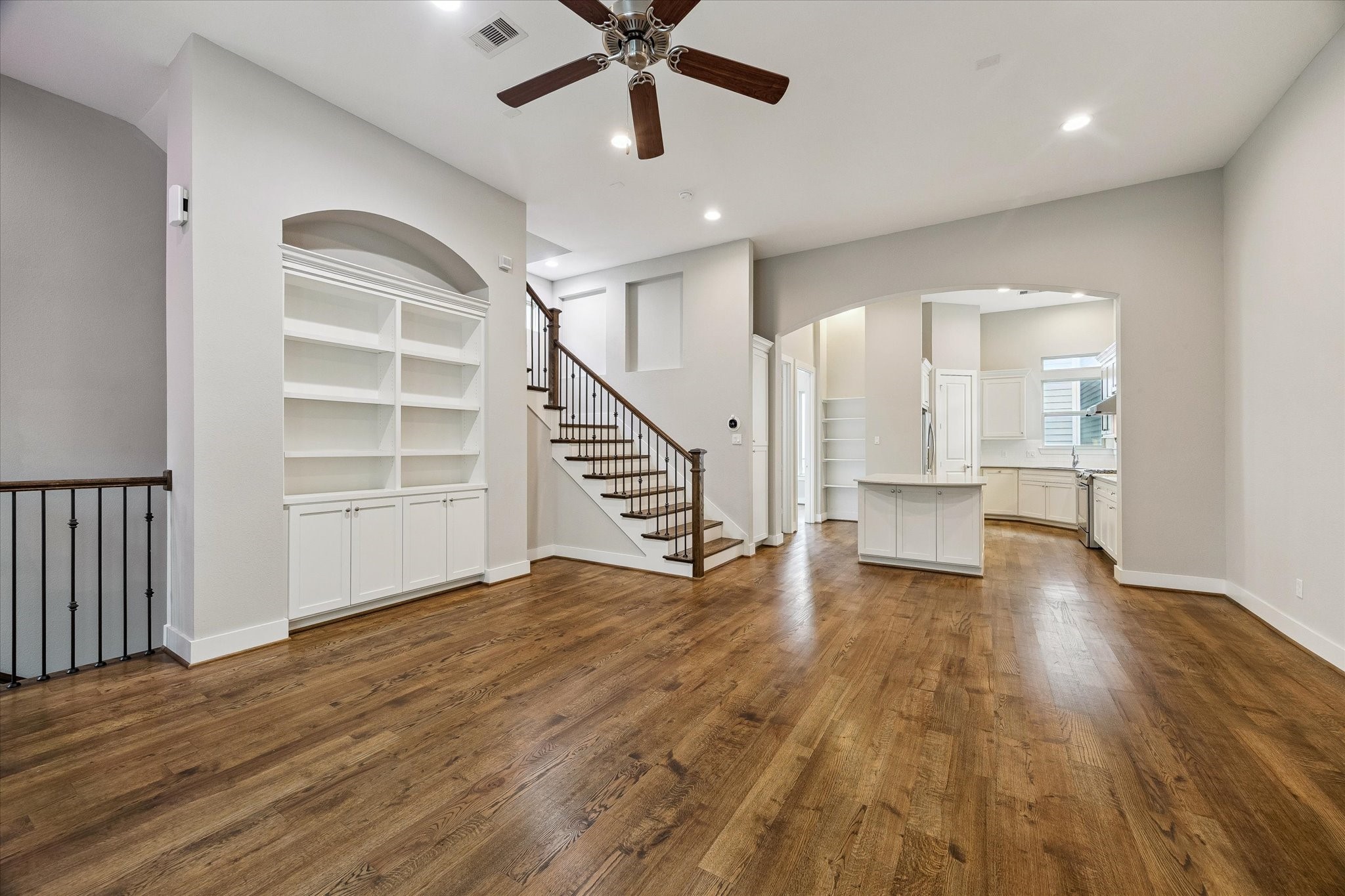 Another view of the spacious living room with tall ceilings and beautiful wood floors.