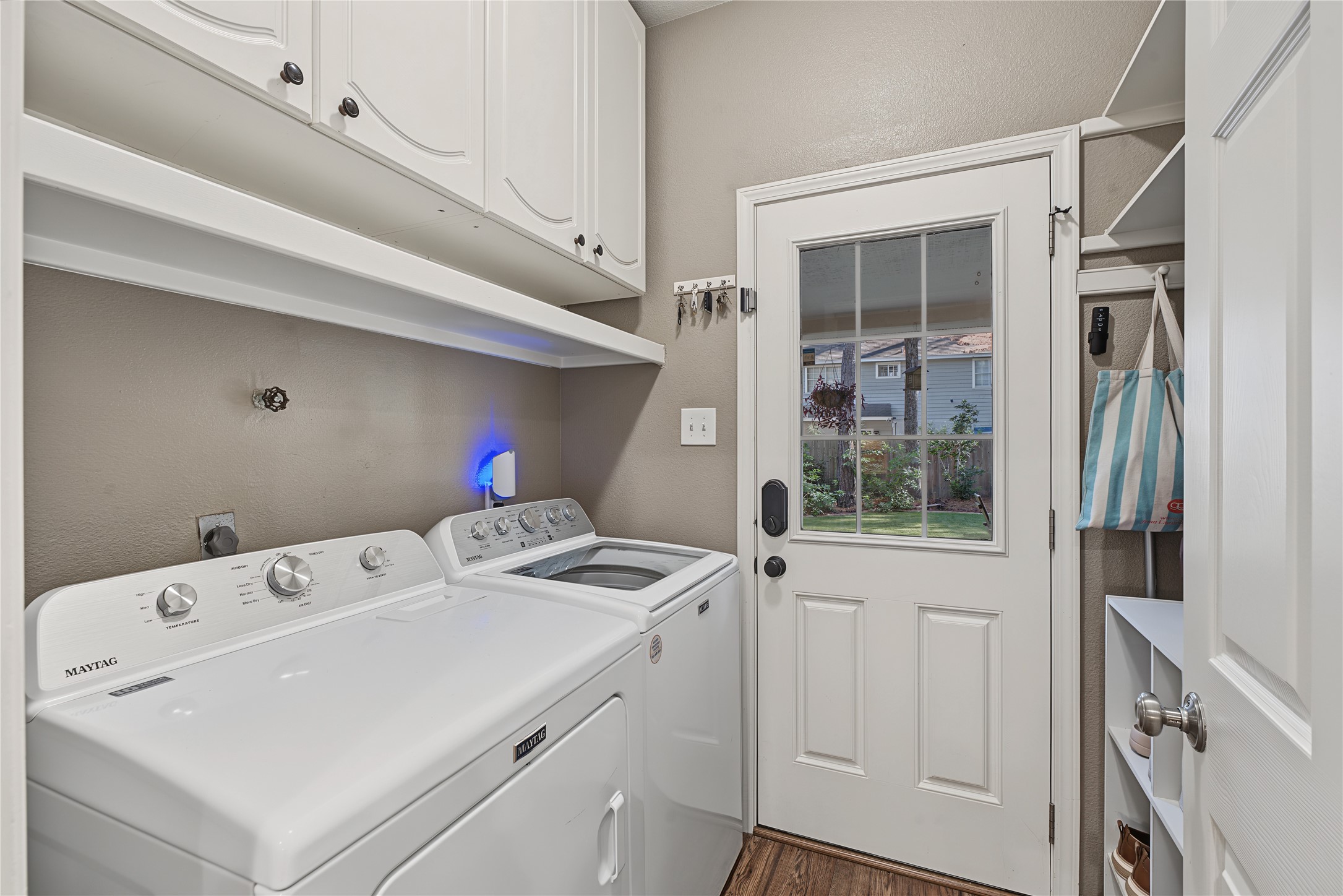 Laundry room with door to back yard and plenty of cabinetry for additional storage.