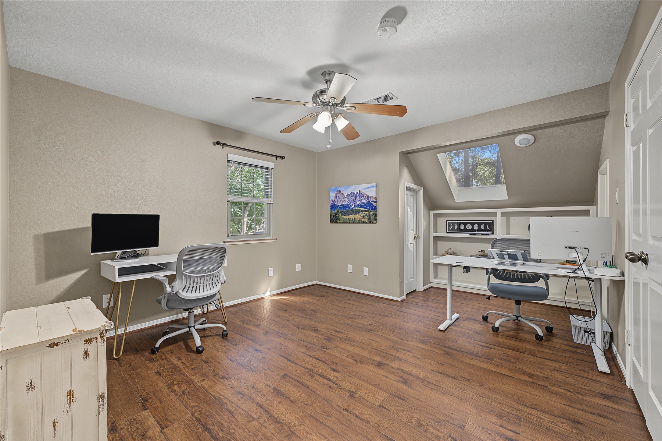The final upstairs bedroom features a stunning skylight and custom built-in shelving plus THREE closets offering versatile storage.