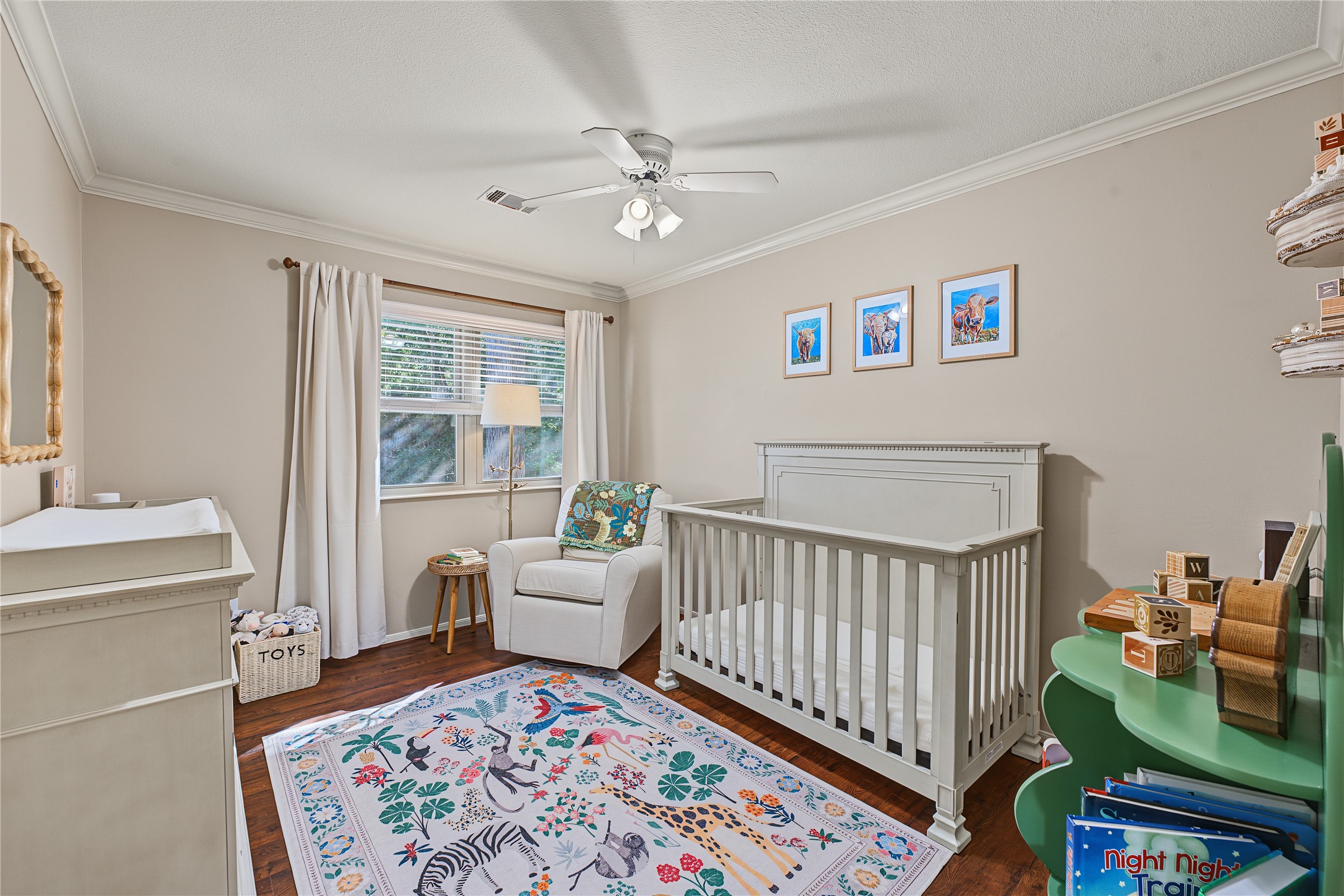 The secondary bedroom closest to the primary suite offers the same elegant crown moulding and fresh neutral paint.