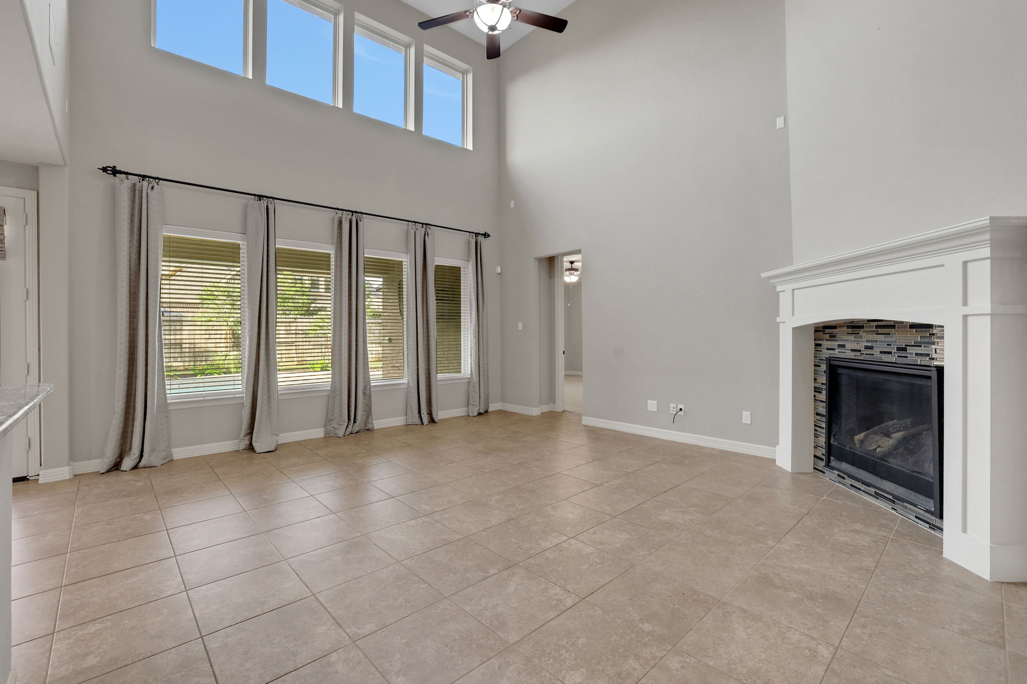 The family room features a wall of windows for an abundance of natural light and a charming fireplace