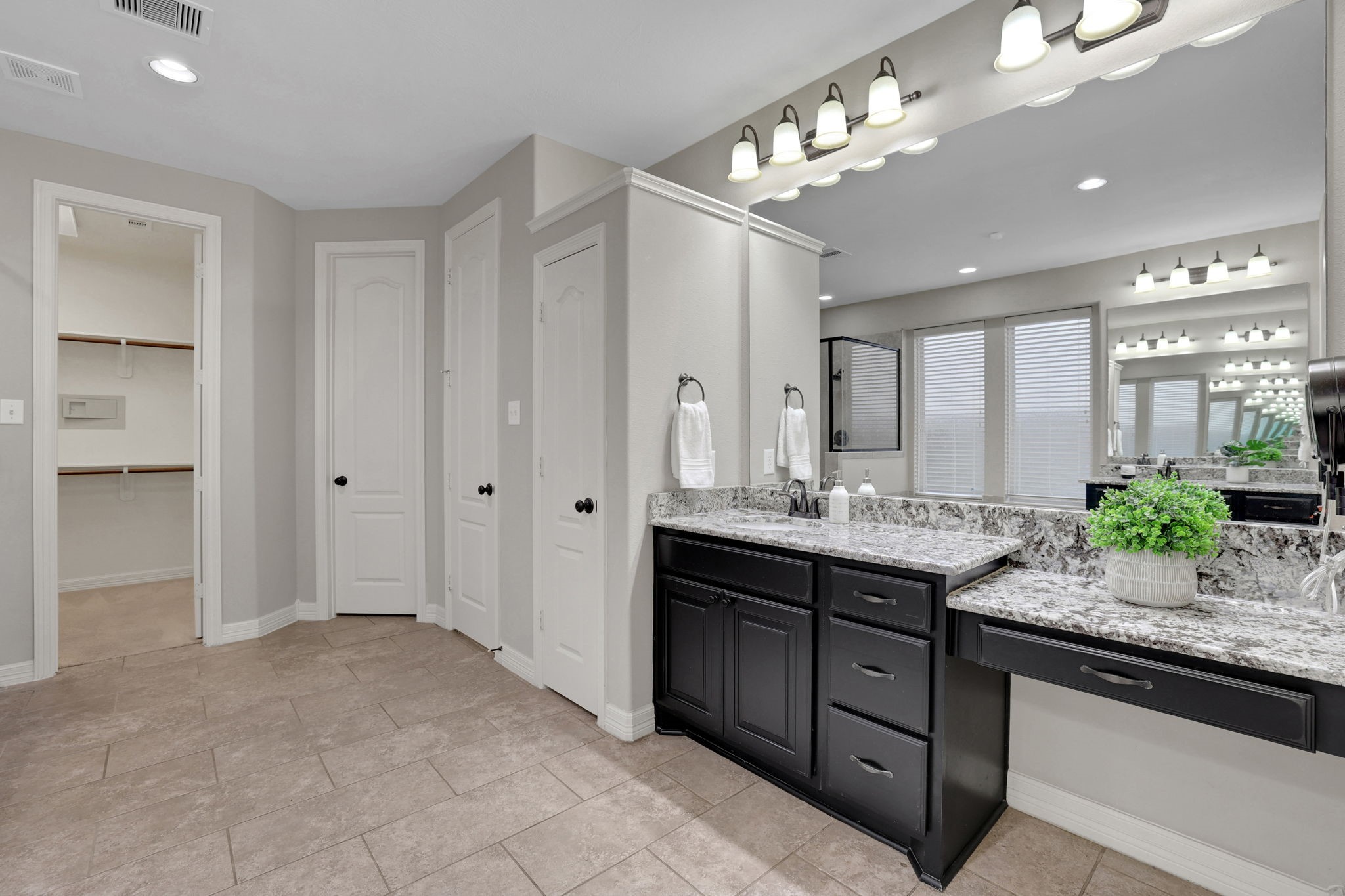Another view of the primary bath showcasing the HUGE walk-in closet and vanity