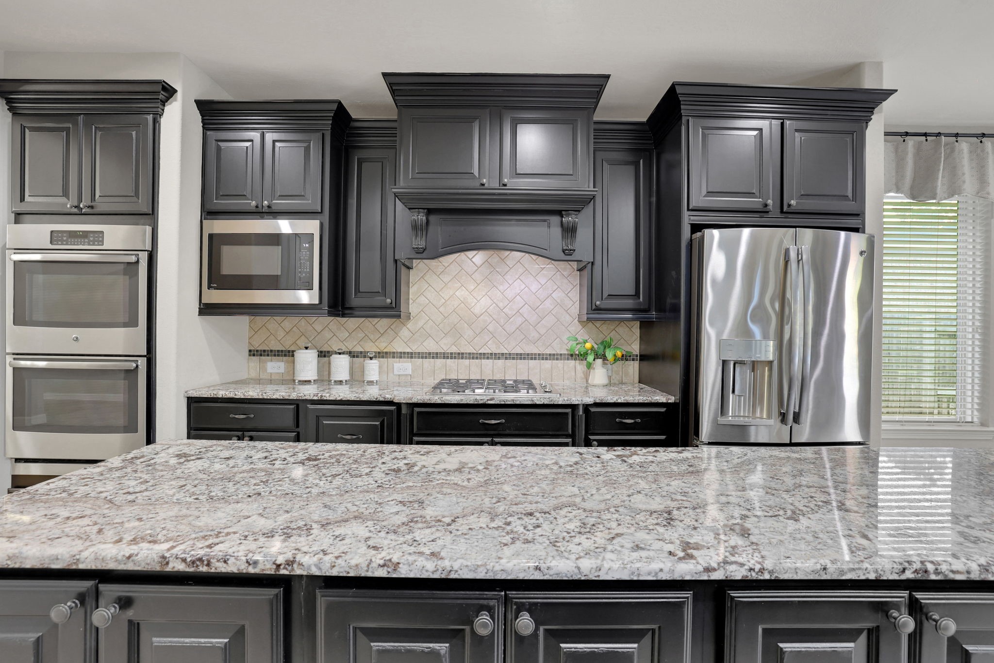 The kitchen features double ovens and ample prep space for the chef in the family