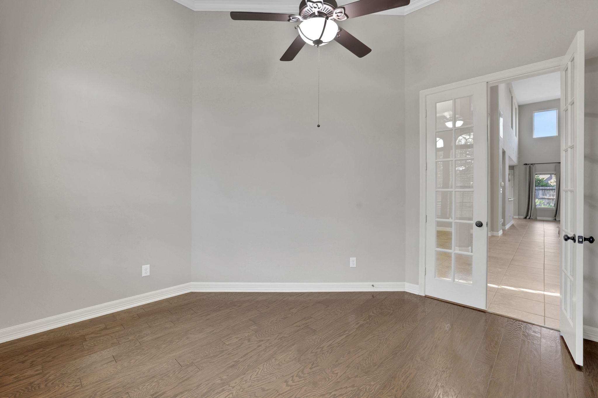 The office has wood floors and French doors for privacy