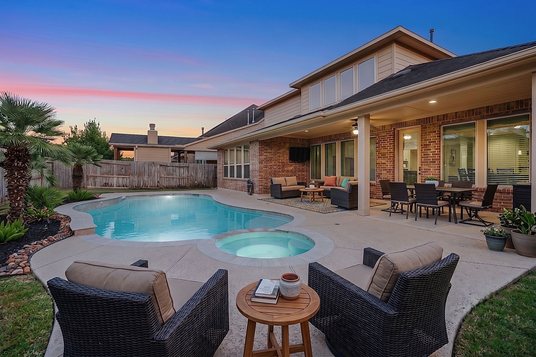 Stunning outdoor oasis featuring a sparkling pool and spa, oversized covered patio, and expansive spaces designed for seamless entertaining.