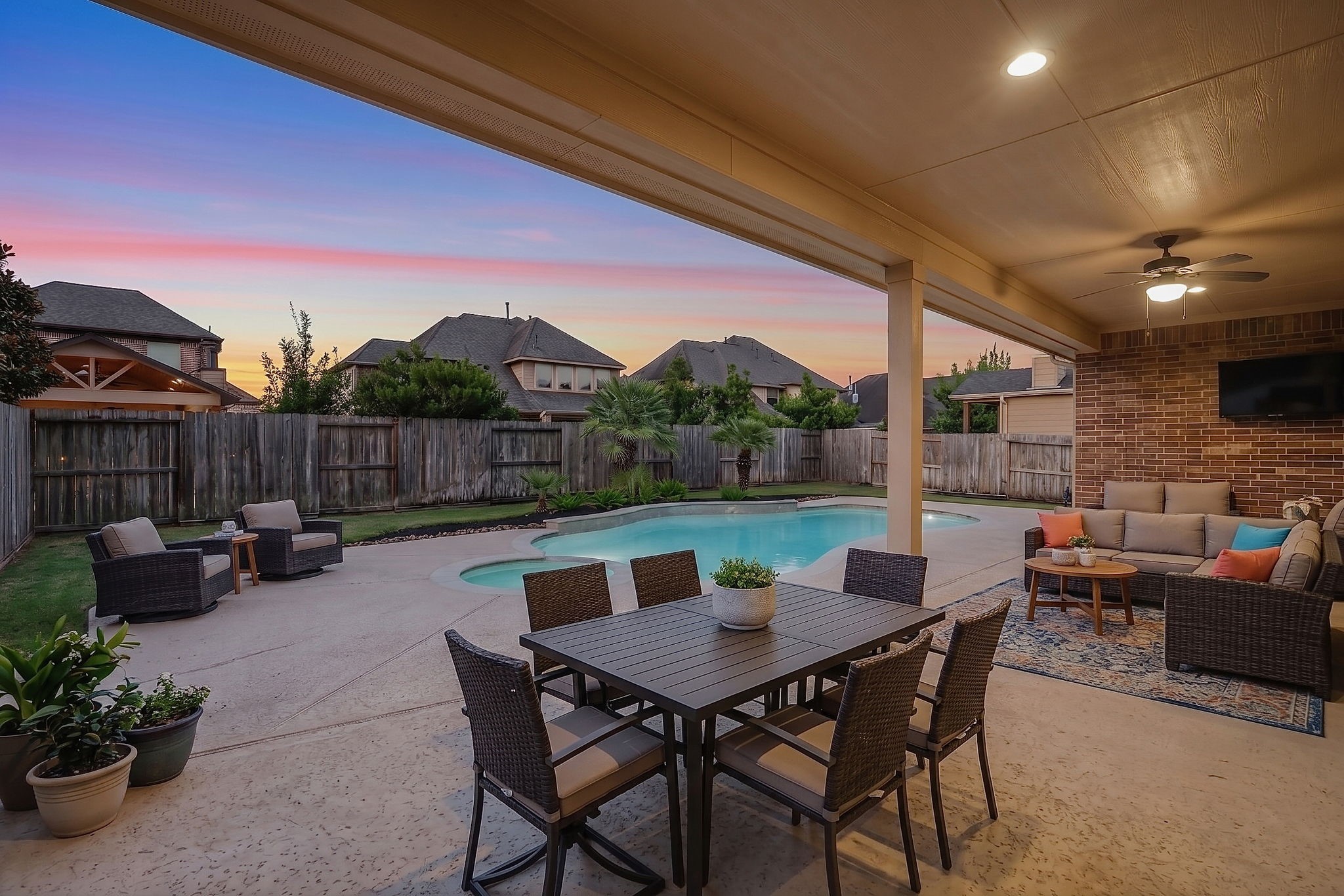 Another view of the expansive backyard oasis, featuring a generous grassy area beyond the pool.