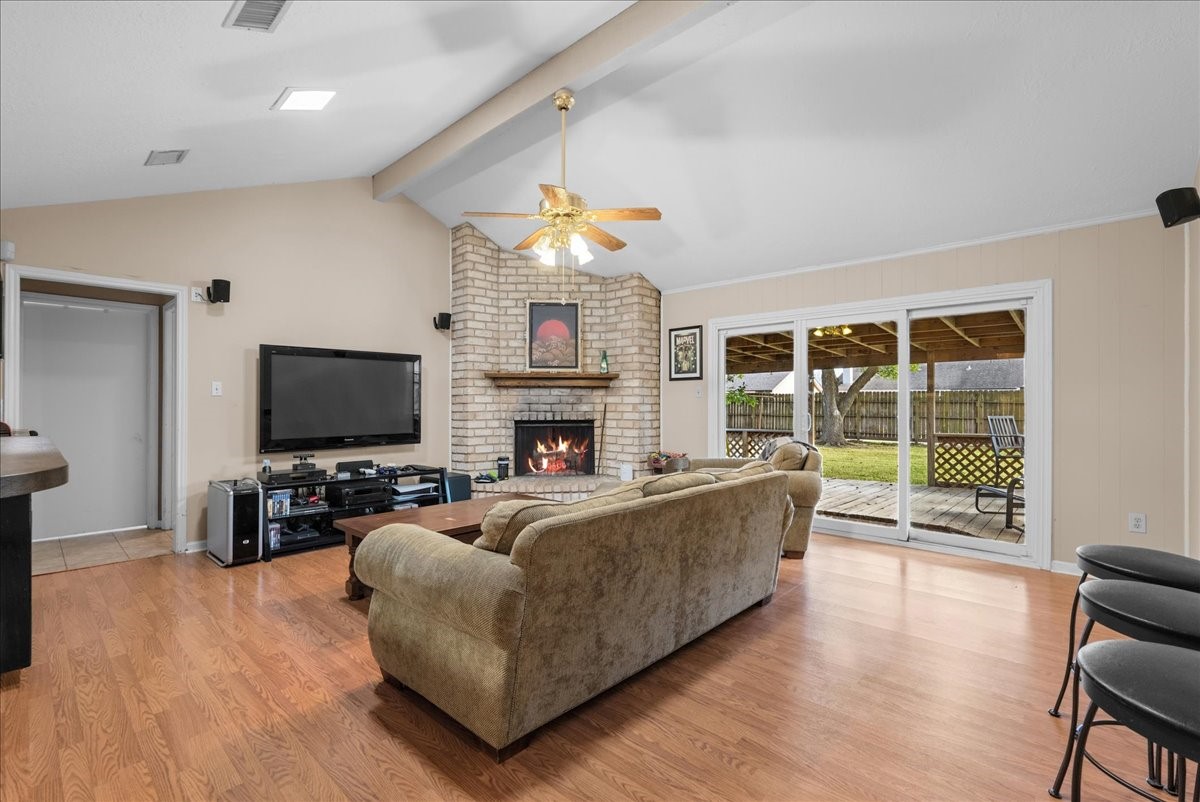 Spacious living room with vaulted ceiling, brick fireplace, and sliding glass doors leading to the covered deck. Spacious living room with vaulted ceiling, brick fireplace, and sliding glass doors leading to the covered deck.