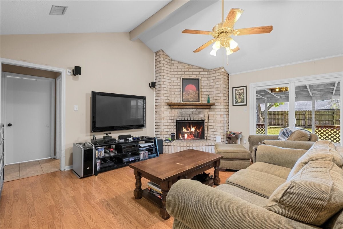 Additional living room view highlighting the brick fireplace and comfortable seating area. Additional living room view highlighting the brick fireplace and comfortable seating area.
