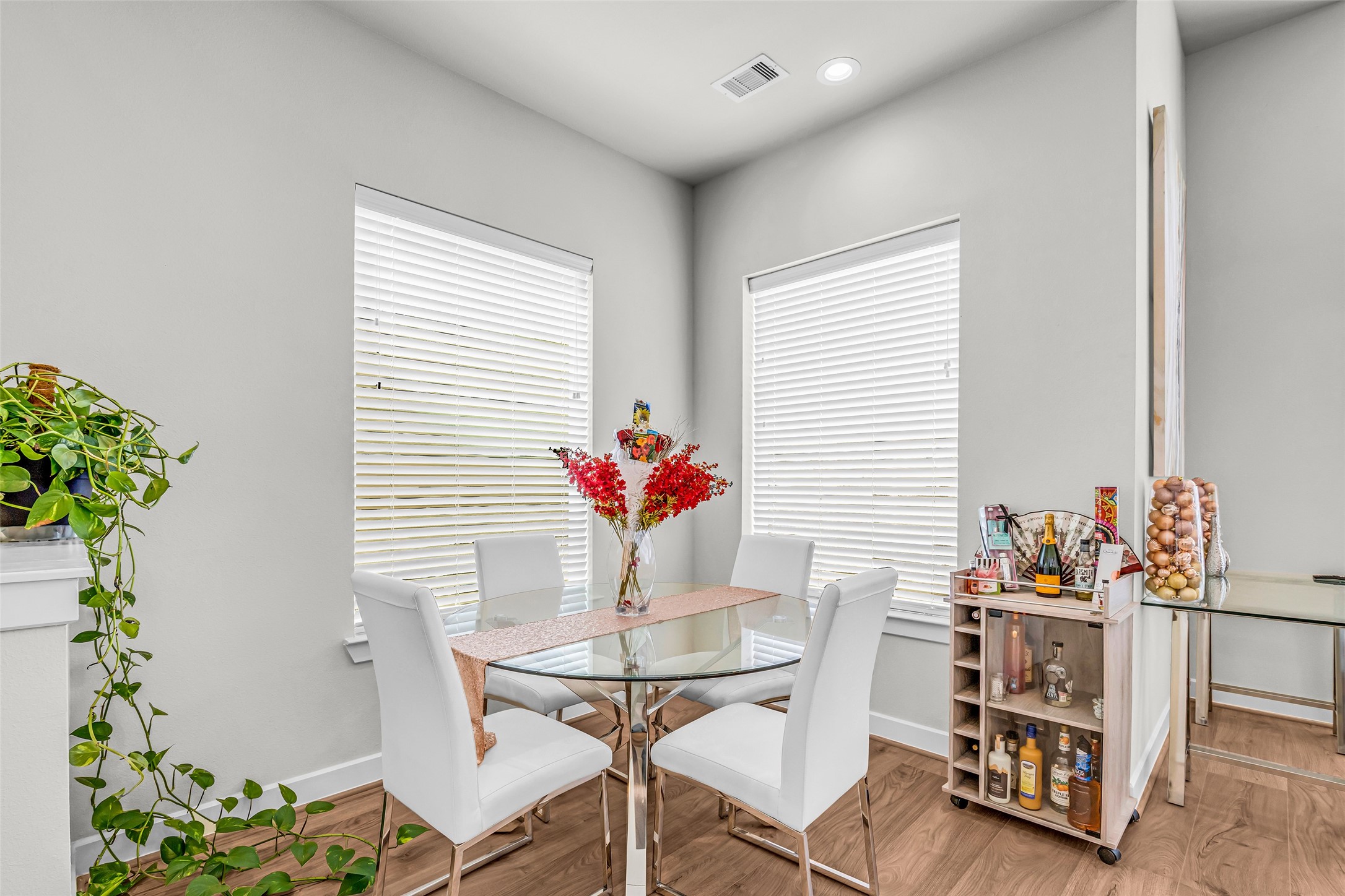 Dining area positioned in a bright corner, illuminated by a pair of windows that bring in natural light and create a pleasant space for meals.