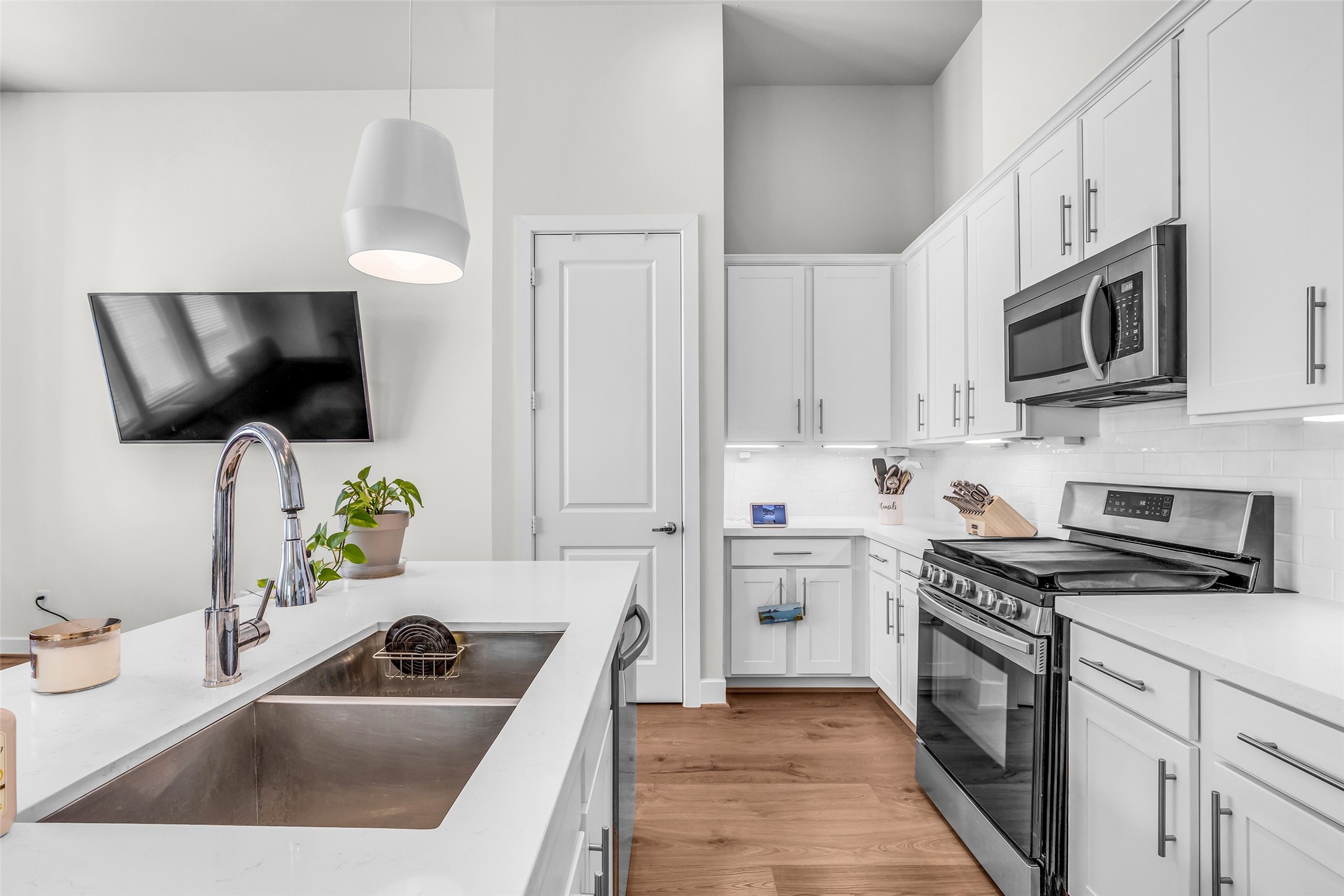 It is equipped with a microwave, dishwasher, gas range, waste disposal, and a double-basin sink, providing the essential features for everyday cooking and cleanup.