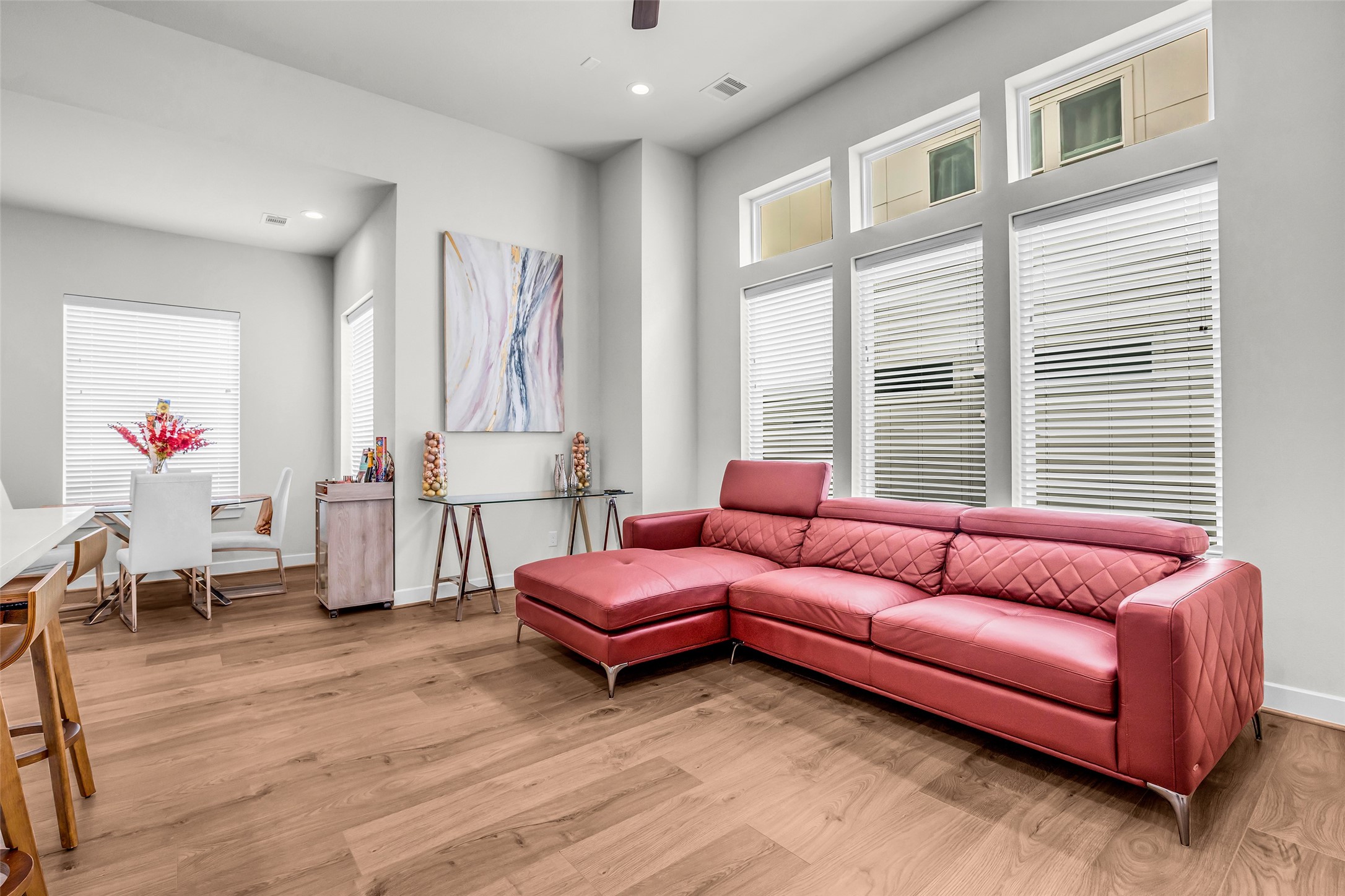Living room featuring warm wood flooring that continues seamlessly into the adjacent living spaces, creating a cohesive and inviting main gathering area.