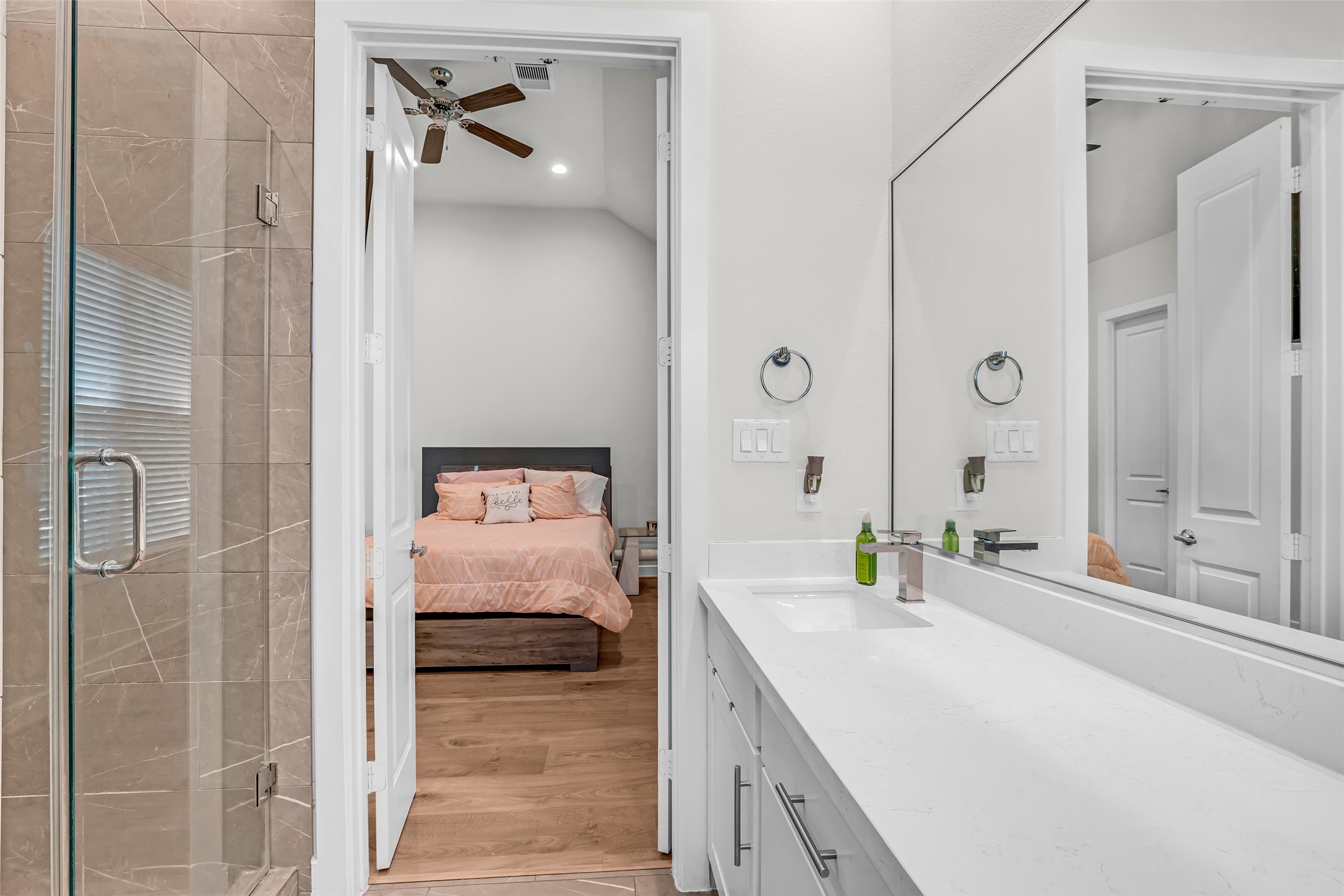 Primary bathroom featuring a separate tub and shower, a large mirror, and double sinks, designed for convenience and everyday functionality.