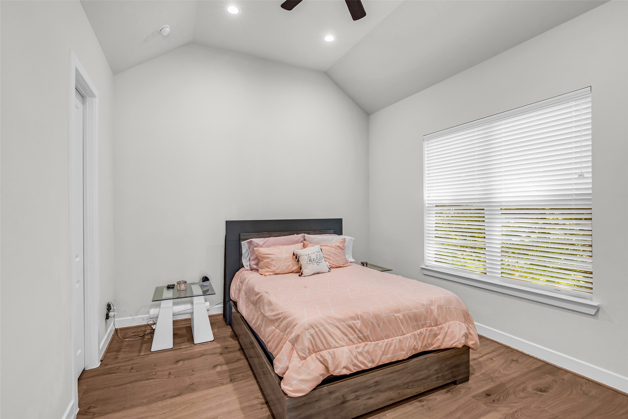 Primary bedroom located on the second floor, featuring wood flooring and a large window with views of the backyard, bringing in natural light and a comfortable atmosphere.