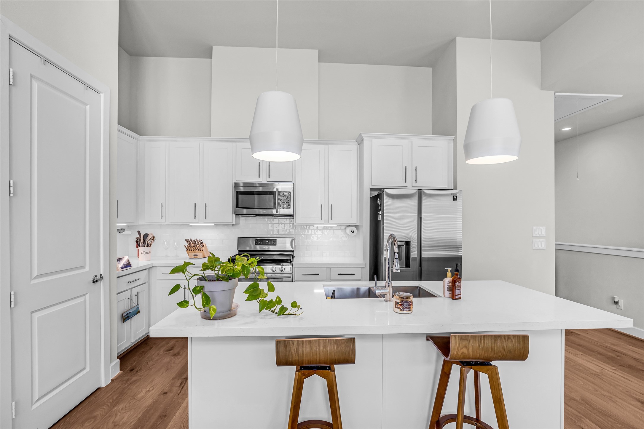 Full view of the kitchen showcasing the layout of the appliances and workspace. The closed door leads to a pantry, providing convenient storage for groceries and kitchen essentials.