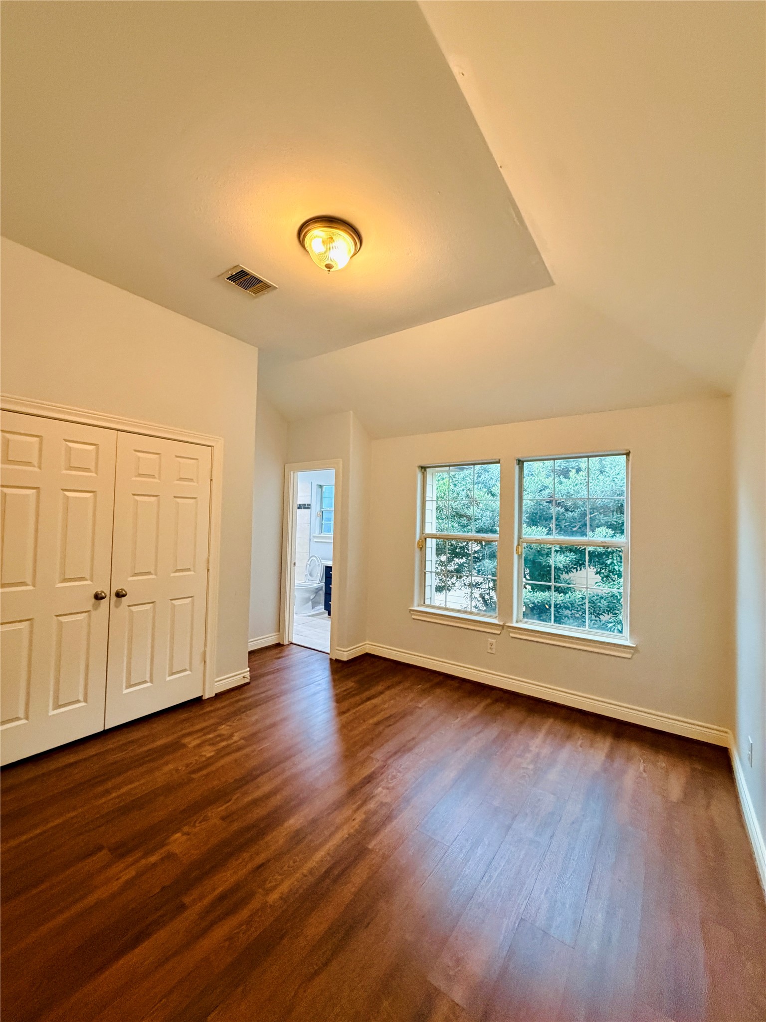 Secondary bedroom with bright windows and a large spacious double-door closet.
