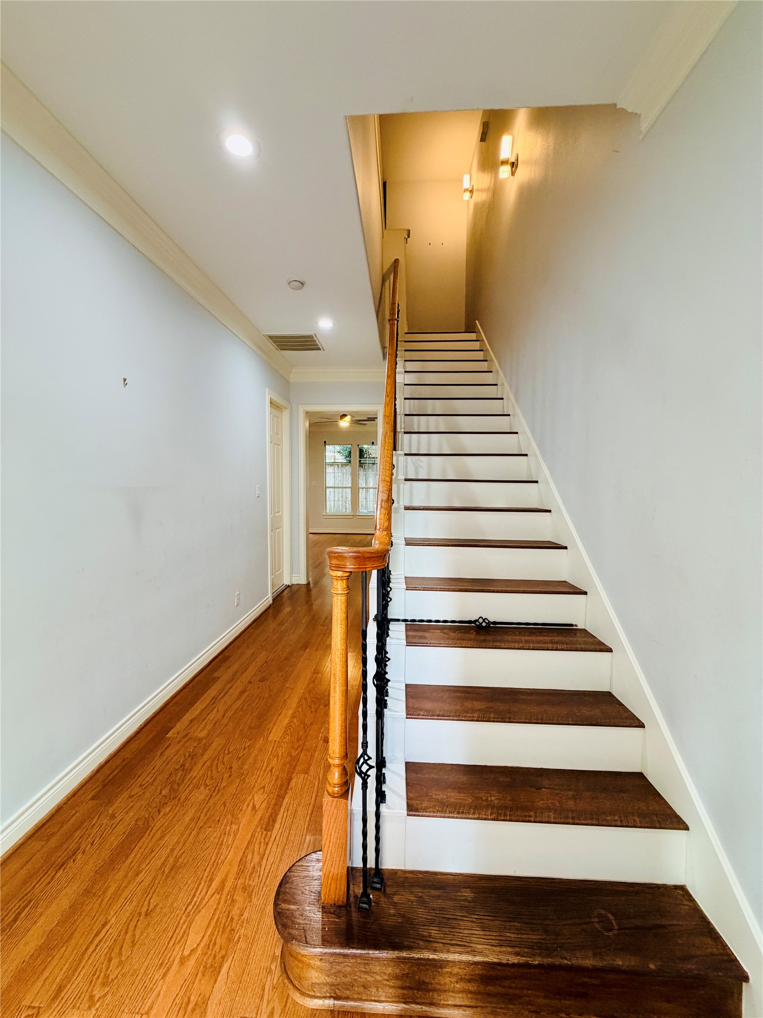 This inviting foyer boasts soaring ceilings, elegant hardwood floors, and refined crown molding.