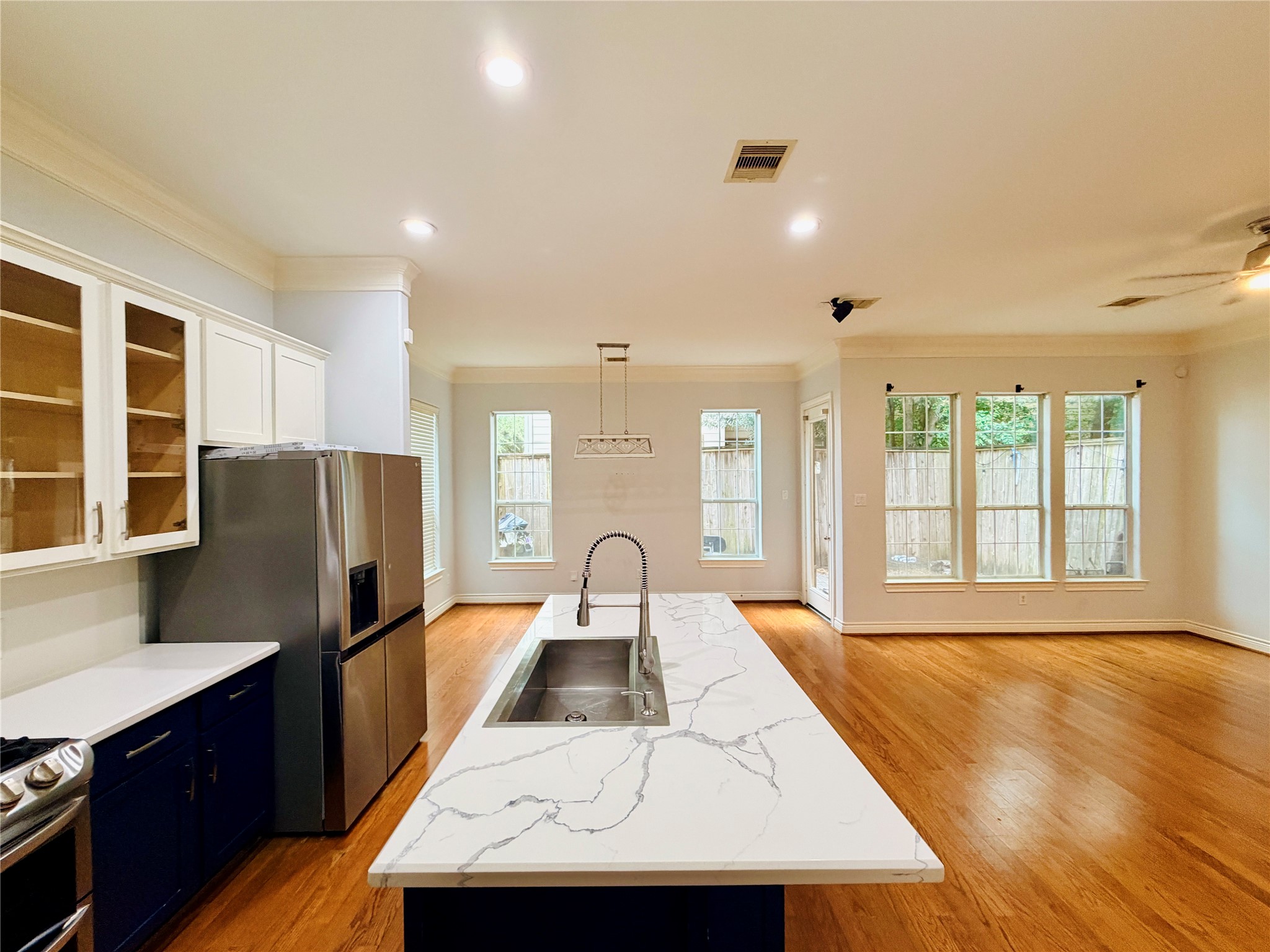 Large windows along the back of the home provide plenty of natural light and views of the backyard, making this open layout perfect for everyday living throughout the kitchen and living area.