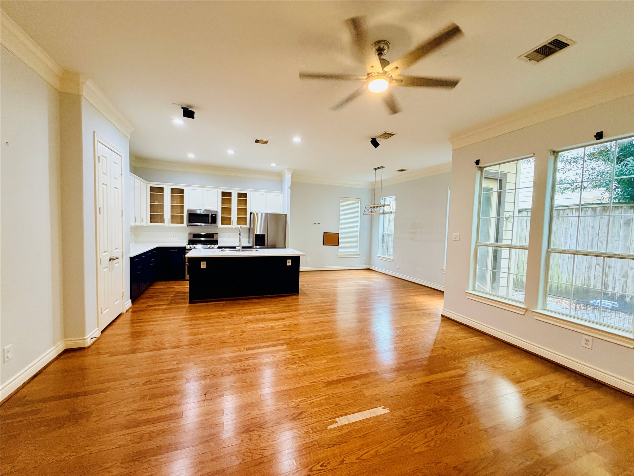 This open-concept kitchen seamlessly connects to the living and dining areas, featuring a spacious center island with elegant quartz countertops.