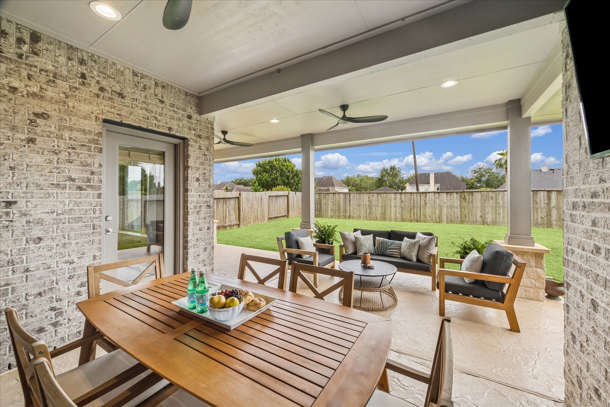 Spacious custom back patio with dedicated dining, grilling, and seating areas, creating a true second living space outdoors.